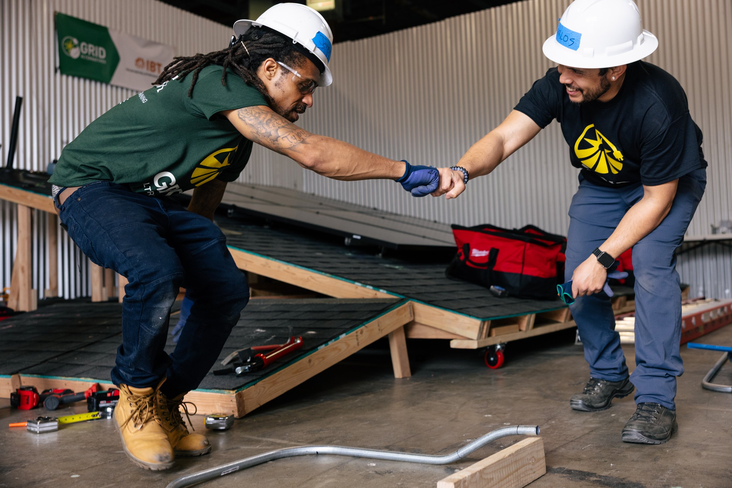 GRID Alternatives IBT 200 trainees work together on solar panel racking during a skills exercise at the training facility in Los Angeles, California.