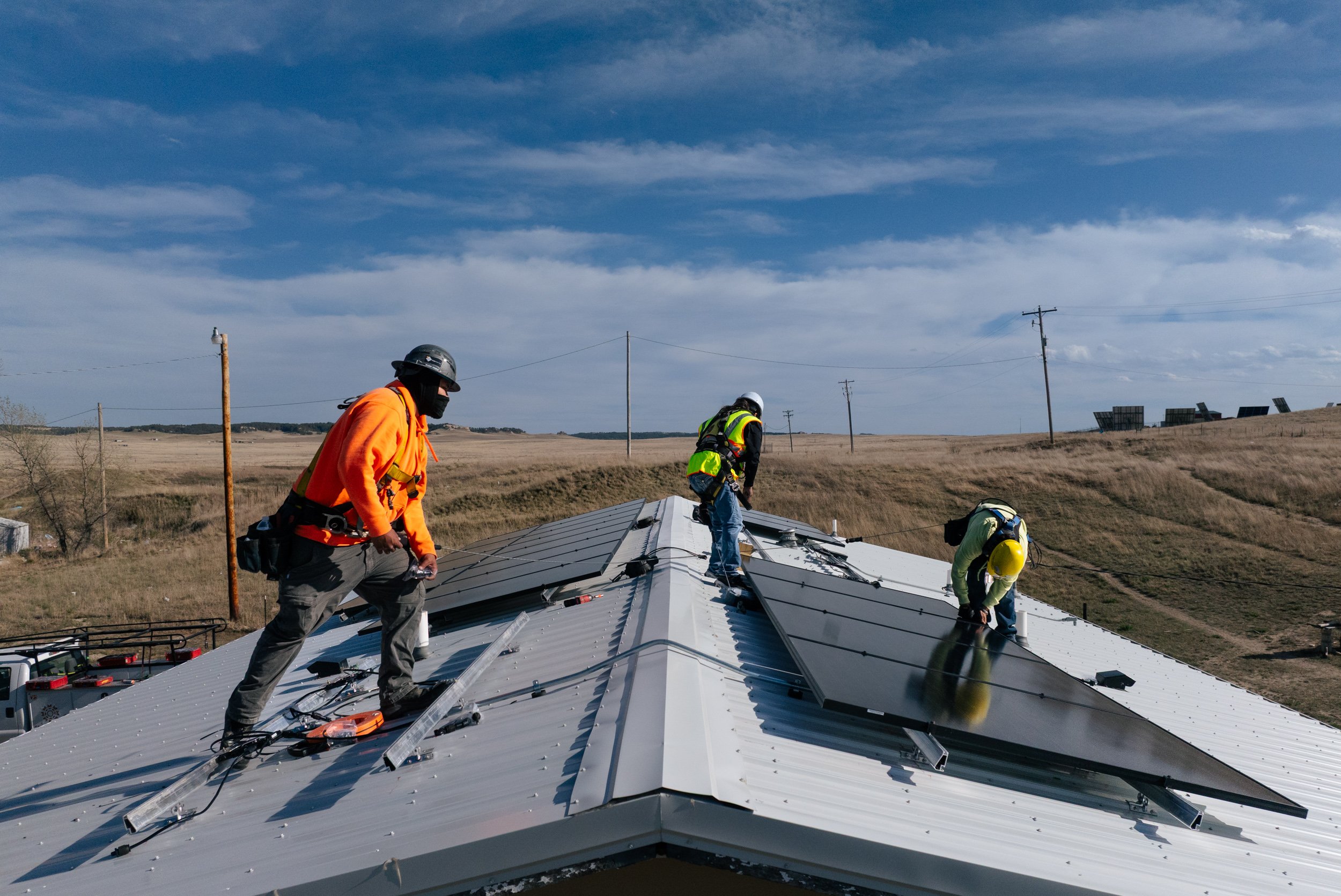 GRID Alternatives installers work on a rooftop solar installation at the Pine Ridge Indian Reservation, South Dakota.