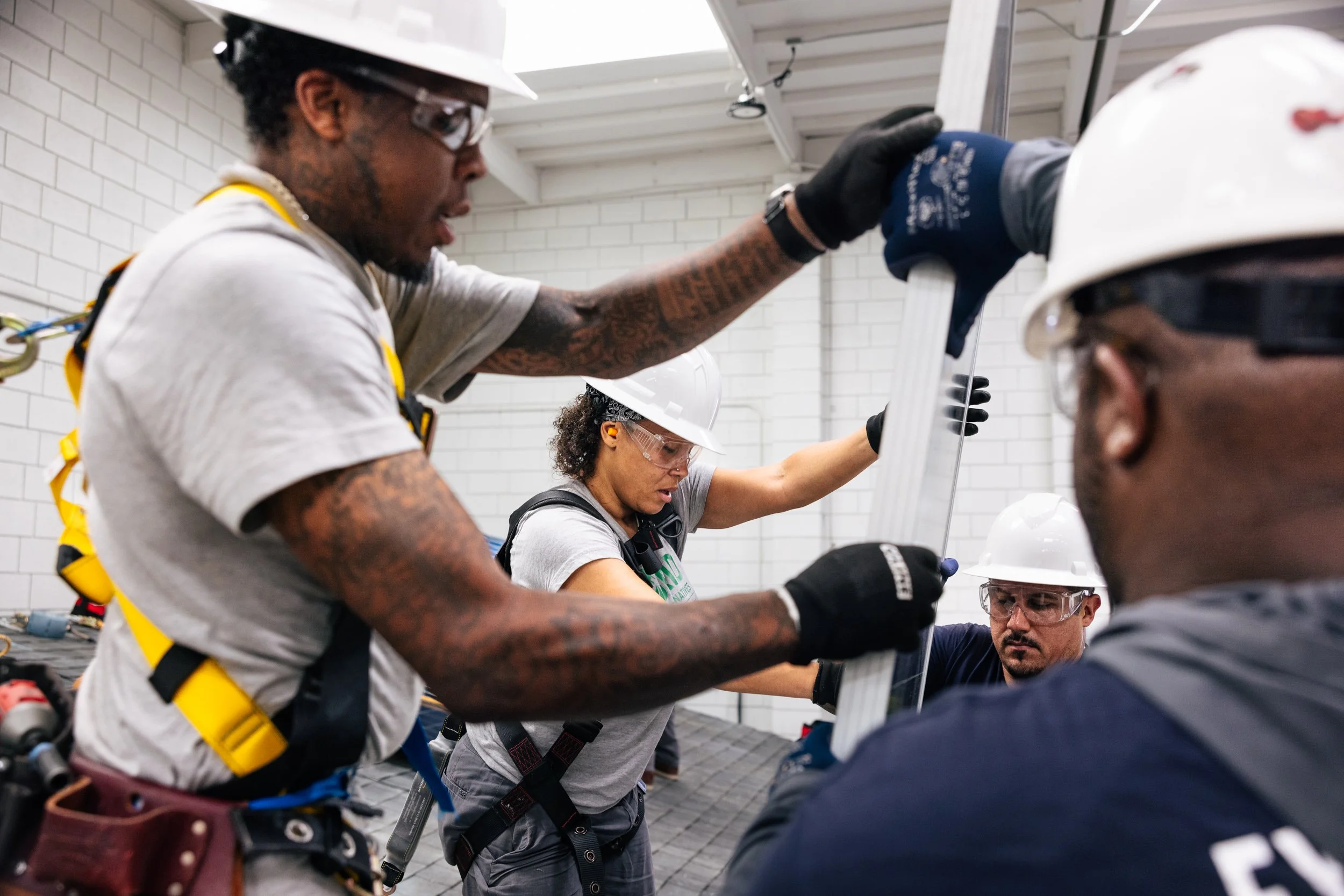 GRID Alternatives IBT 200 trainees work together on solar installation equipment during training in Los Angeles, California.