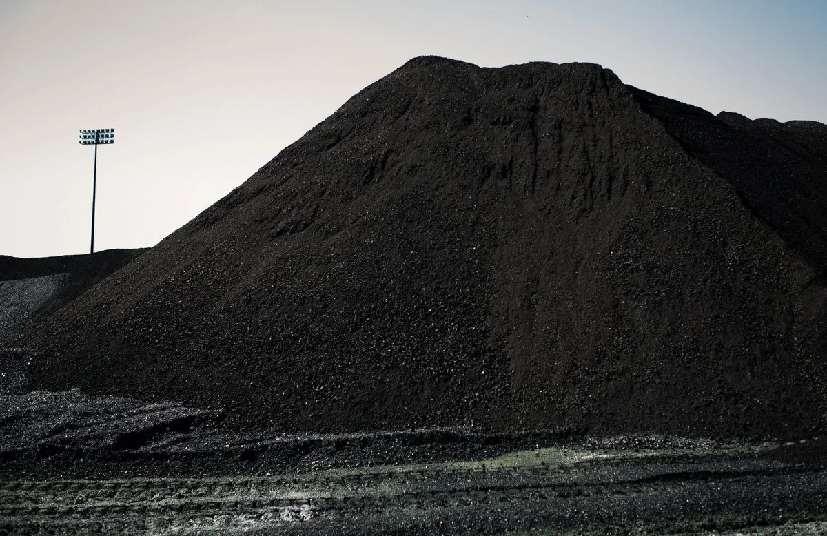 Coal is piled outdoors. Washington, D.C.-based photographer, videographer and writer, newspapers, magazines, nonprofits, NGOs, foundations and corporations. Advertising, marketing.