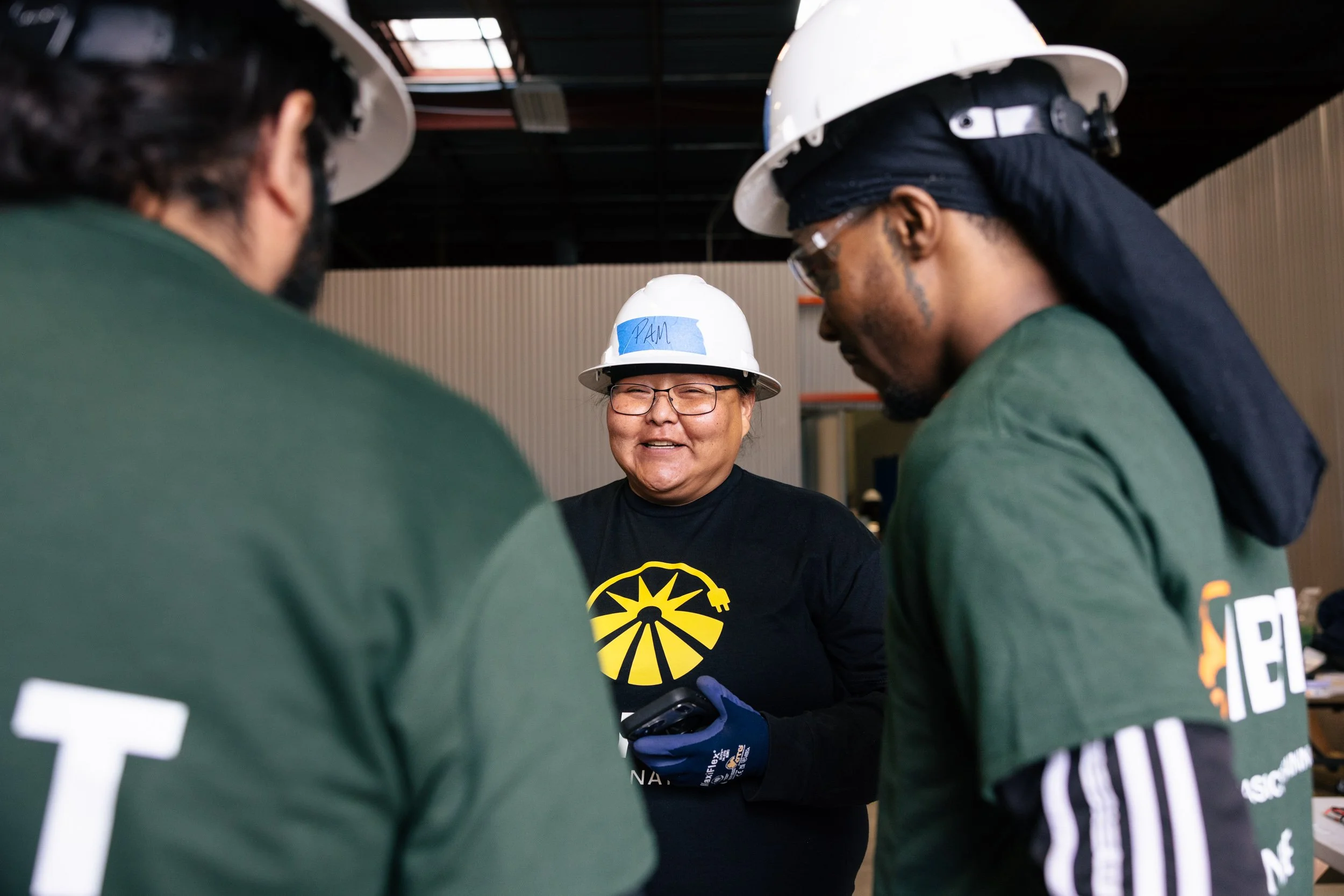 A GRID Alternatives trainer speaks with IBT 200 solar installation trainees at the training facility in Los Angeles, California.
