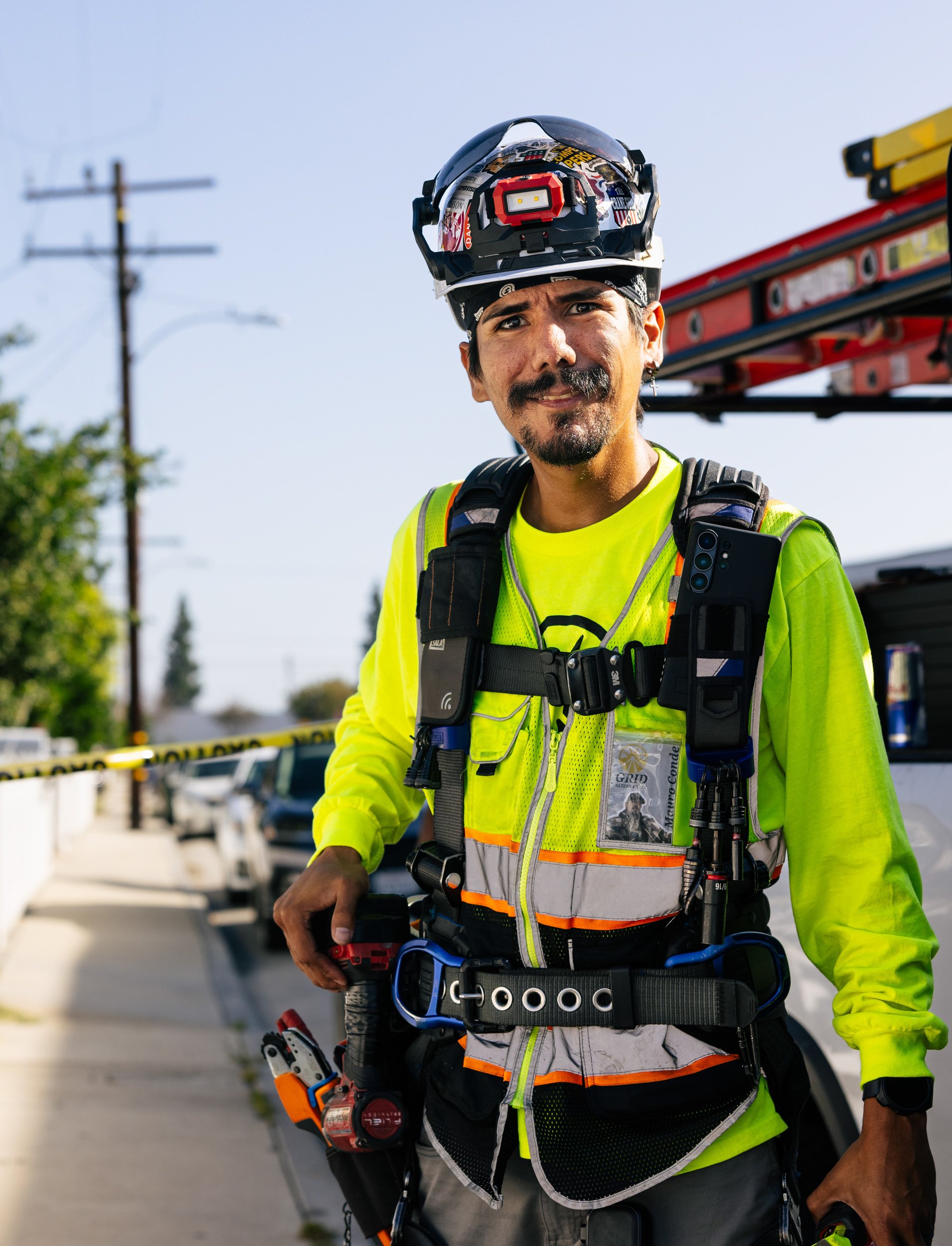 Portrait of a GRID Alternatives solar installer in full safety gear at a residential installation site in Los Angeles, California.