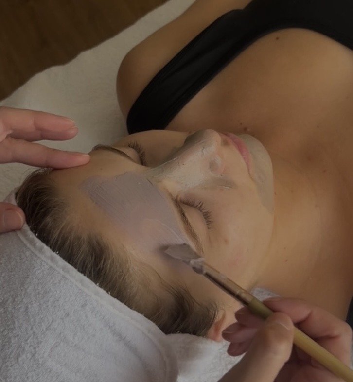A woman receiving a facial treatment at a spa or skincare clinic.
