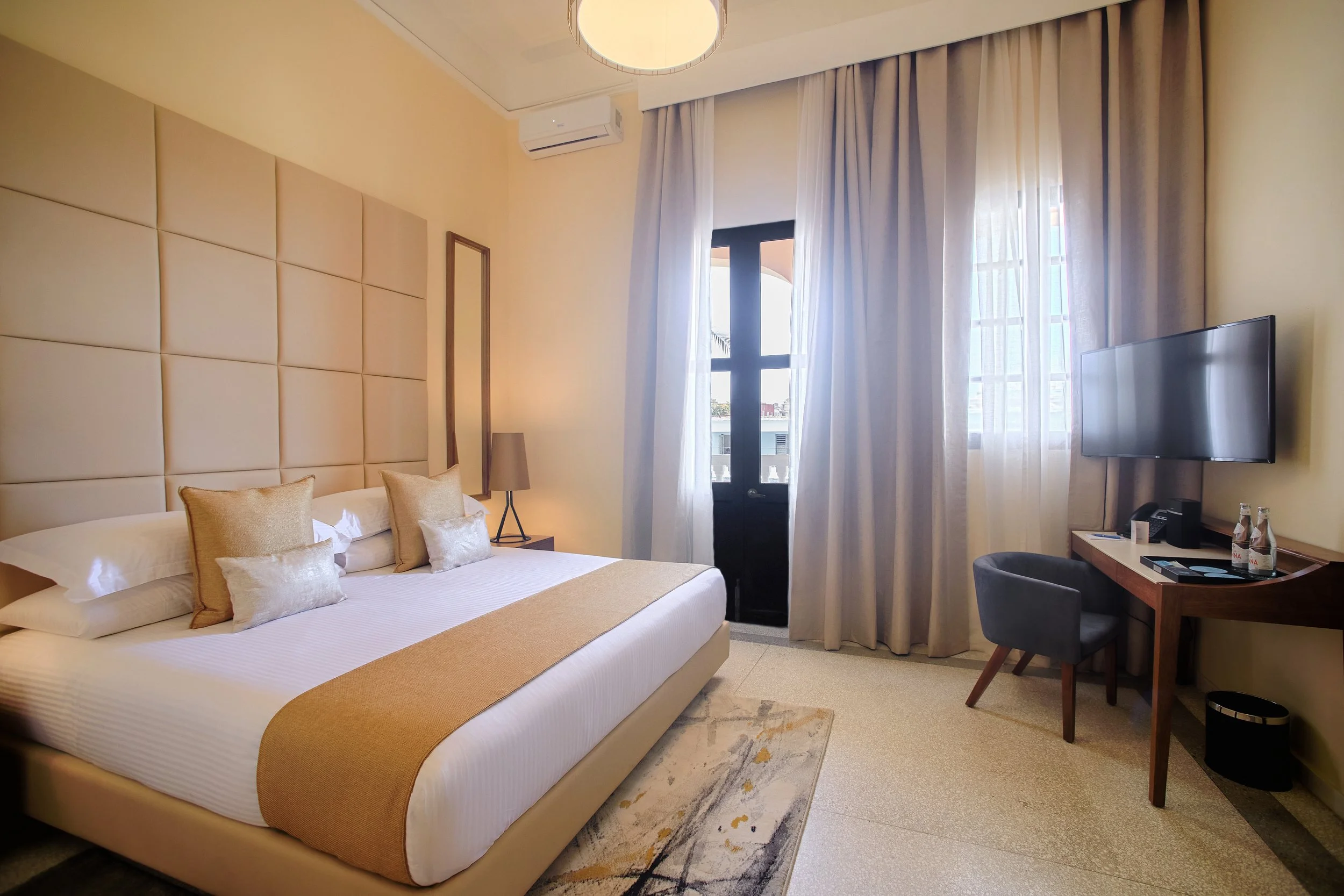 Terraza Junior Suite en VOYA Boutique Hotel con cama king, tonos neutros, balcón privado y elegante mobiliario moderno.