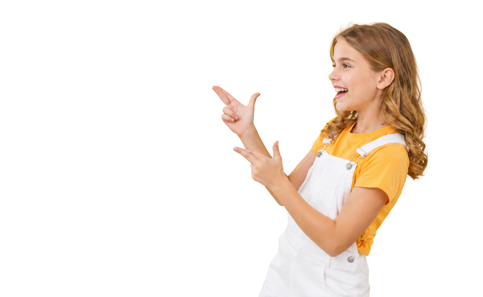 A young girl with curly blonde hair wearing a yellow t-shirt and white overalls, smiling and pointing to her left.