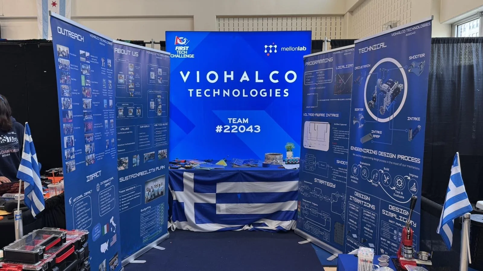 Το pit της ομάδας FTC VIOHALCO TECHNOLOGIES #22043 του MellonLab στο Chicago Robotics Invitational 2026, με τεχνικές παρουσιάσεις, ελληνικές σημαίες και στοιχεία της πορείας της ομάδας.