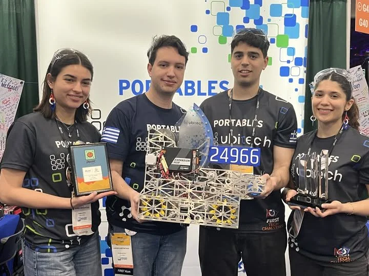 Οι μέντορες της ομάδας Portables UBITECH #24966 του MellonLab φωτογραφίζονται με το αγωνιστικό ρομπότ και τα βραβεία που κατέκτησε η ομάδα στο FIRST Tech Challenge World Championship 2026 στο Houston.