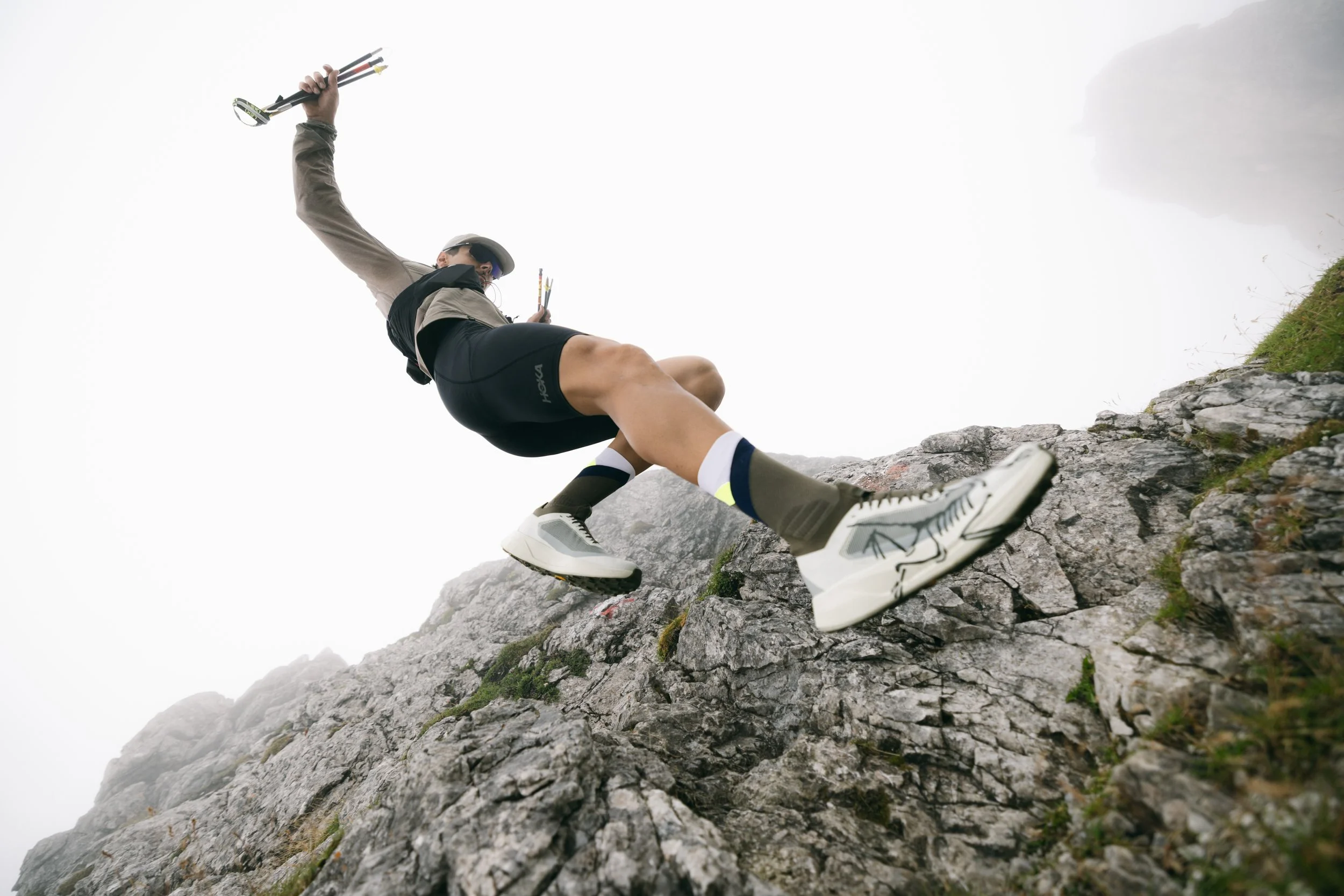 Ein Mountainbiker klettert an einer felsigen Steilwand in den Bergen empor, trägt einen Helm und trägt Fahrradschuhe.