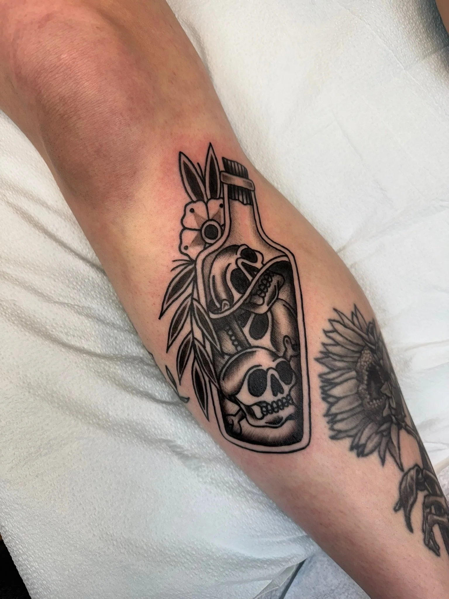 Traditional tattoo of a poison bottle in black and gray ink by Leah Fries, located at Moth to a Flame Tattoo, Old Colorado City