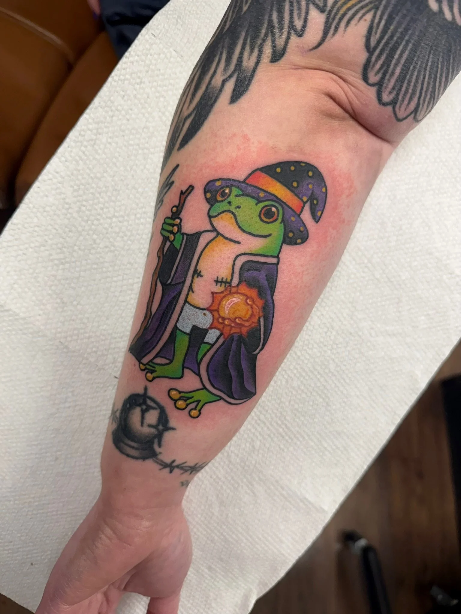 Cute wizard frog tattoo in full color ink by Leah Fries located at Moth to a Flame Tattoo in Colorado Springs