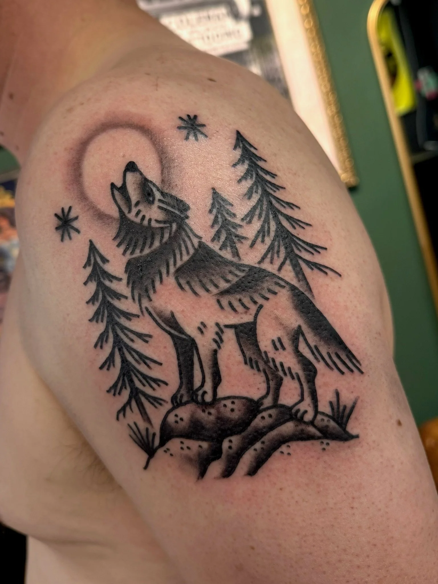 Traditional tattoo of a wolf howling at the moon in black and gray ink by Leah Fries, located at Moth to a Flame Tattoo, Colorado Springs