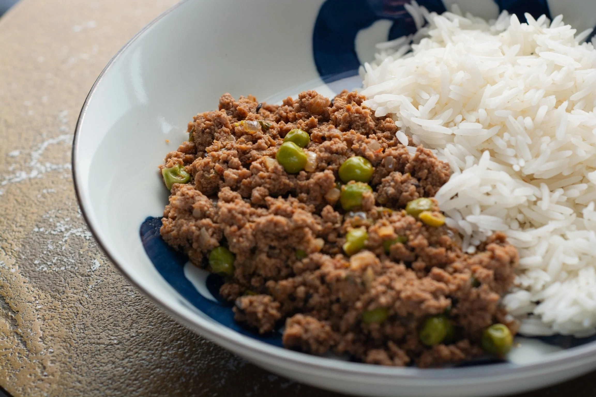 Plato de arroz blanco con carne molida y guisantes.
