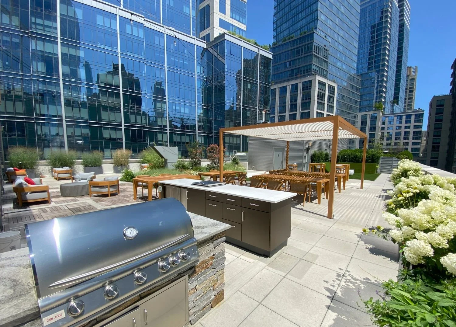 Rooftop outdoor kitchen, grill, bar, and a pergola for dining in NYC