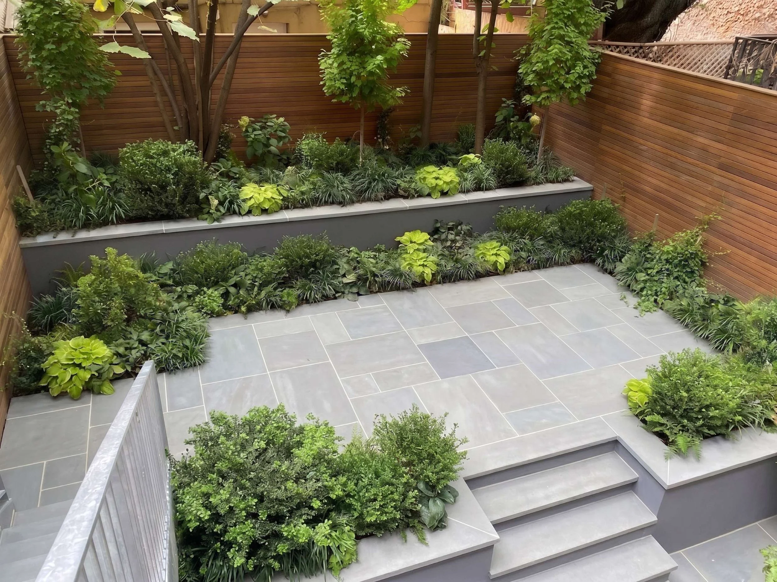 Traditional bluestone patio with Ipe wood fence. Shade garden in NYC
