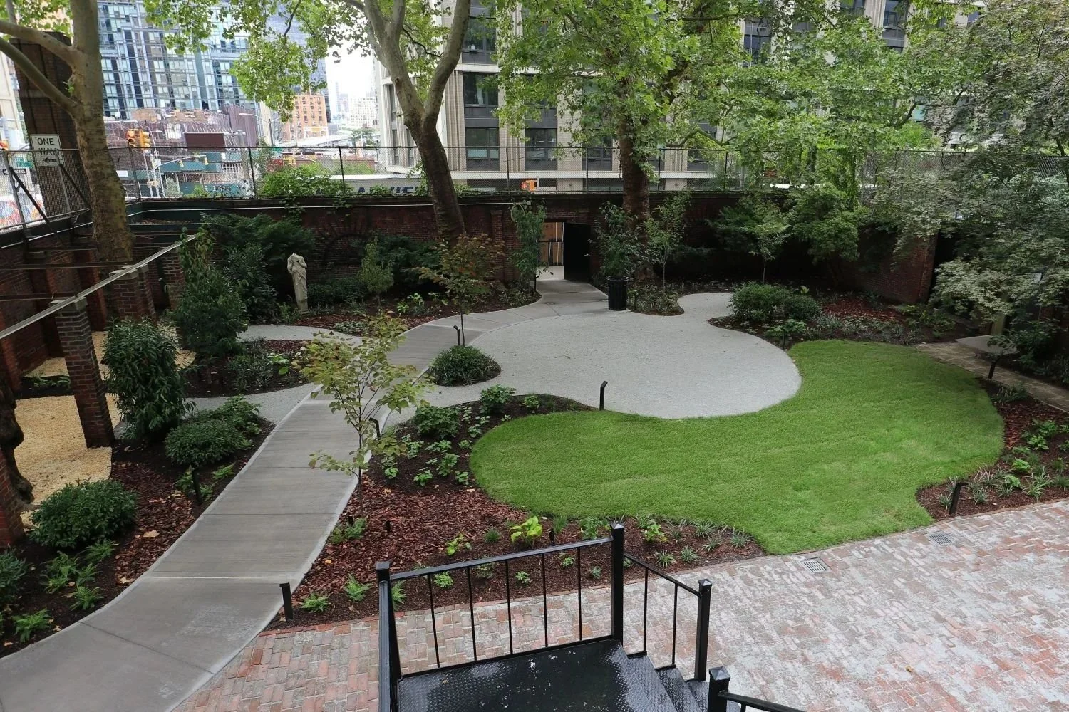 Courtyard landscape design with open lawn and crushed gravel gathering spaces
