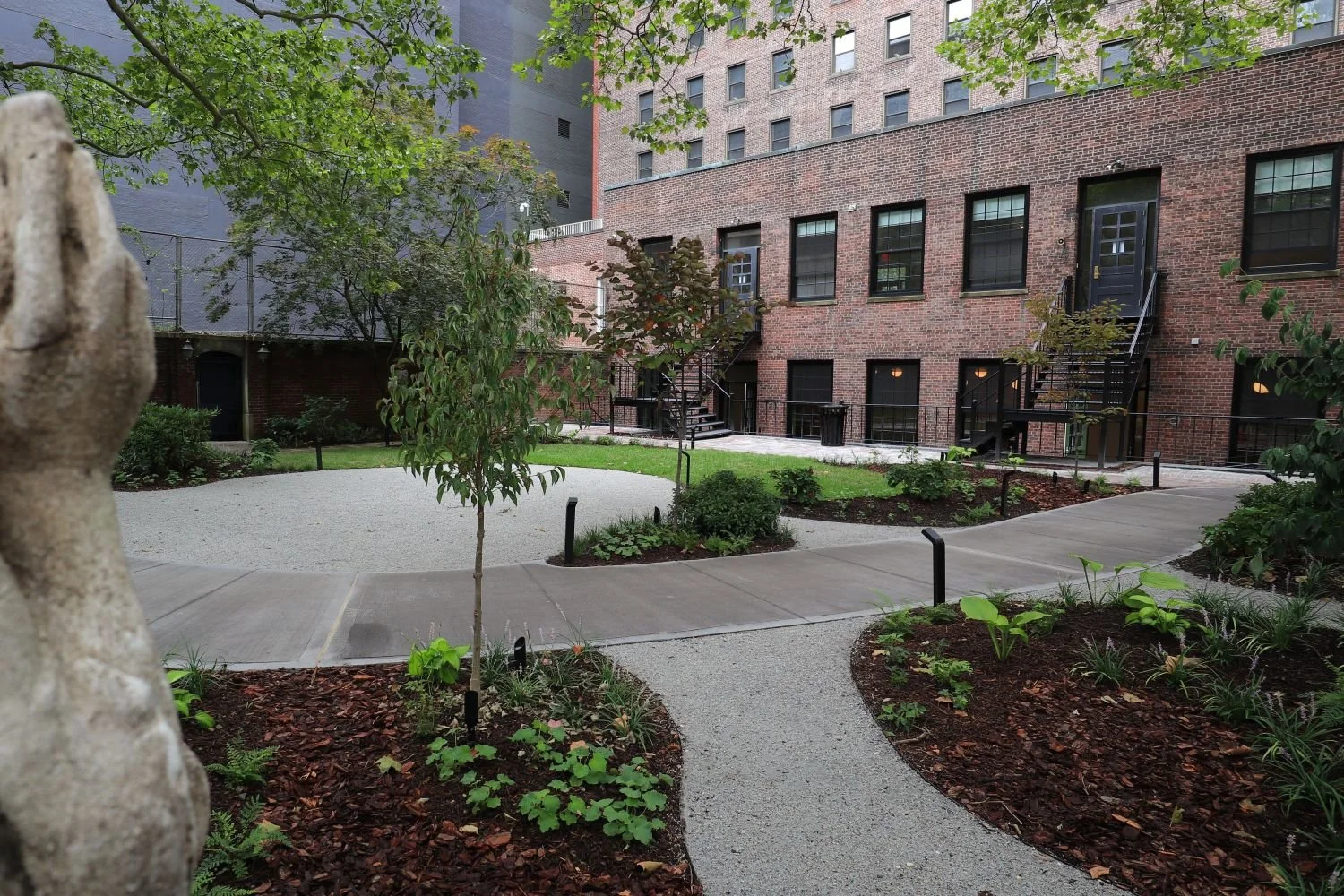 A mix of traditional and modern landscape design elements and forms. Brick and gravel patio