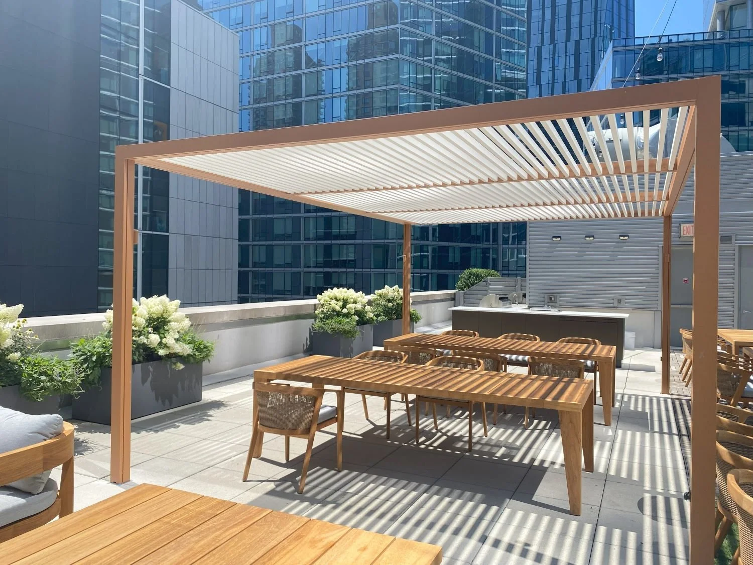 Rooftop amenity space with a bar, and pergola for dining in NYC