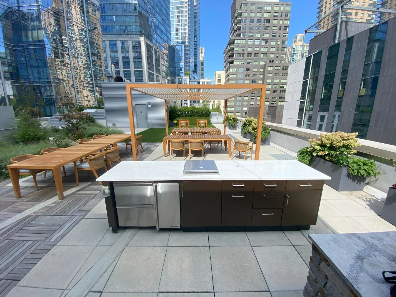 Rooftop amenity space with a bar, and pergola for dining