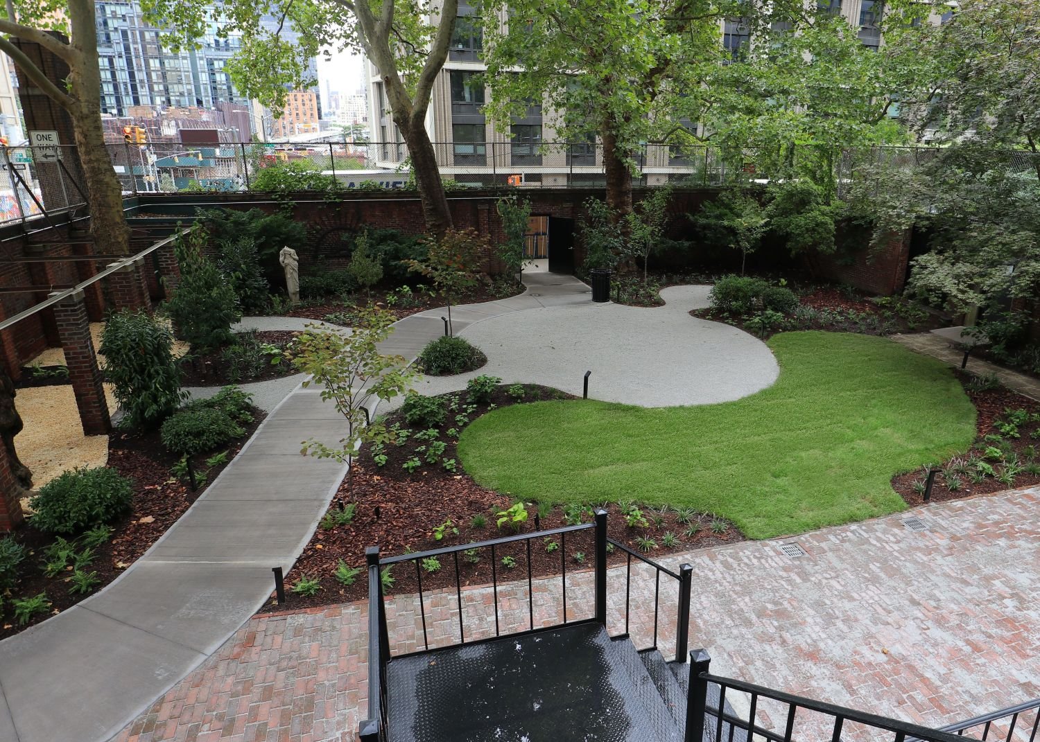 A mix of traditional and modern landscape design elements and forms. Brick and gravel patio