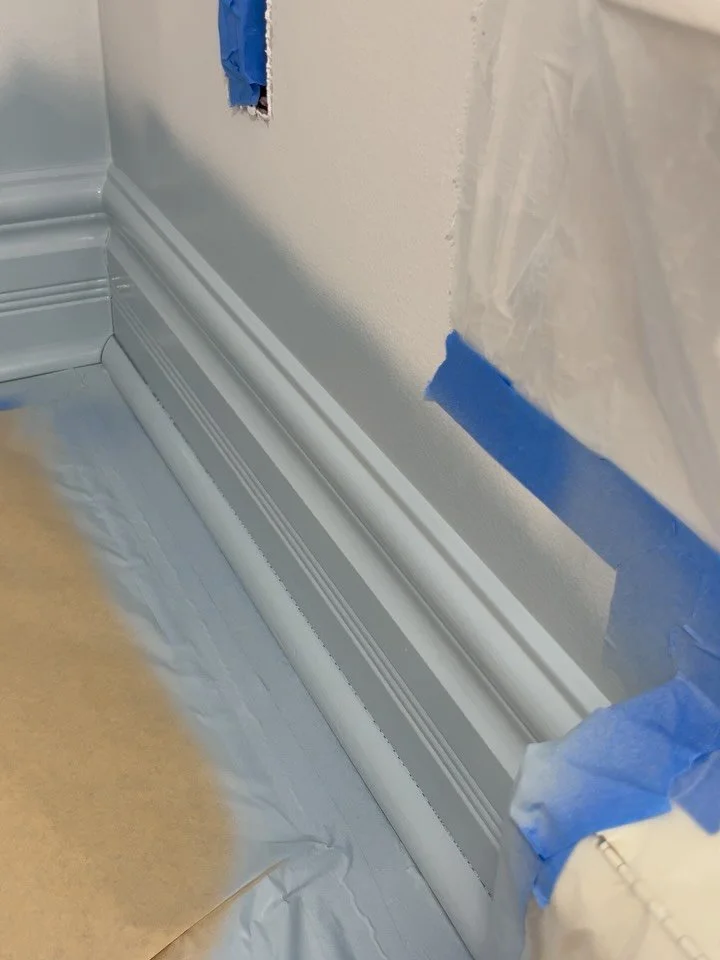 Spraying some trim for a couloir drench in this  dining room using Benjamin Moore Slate Blue