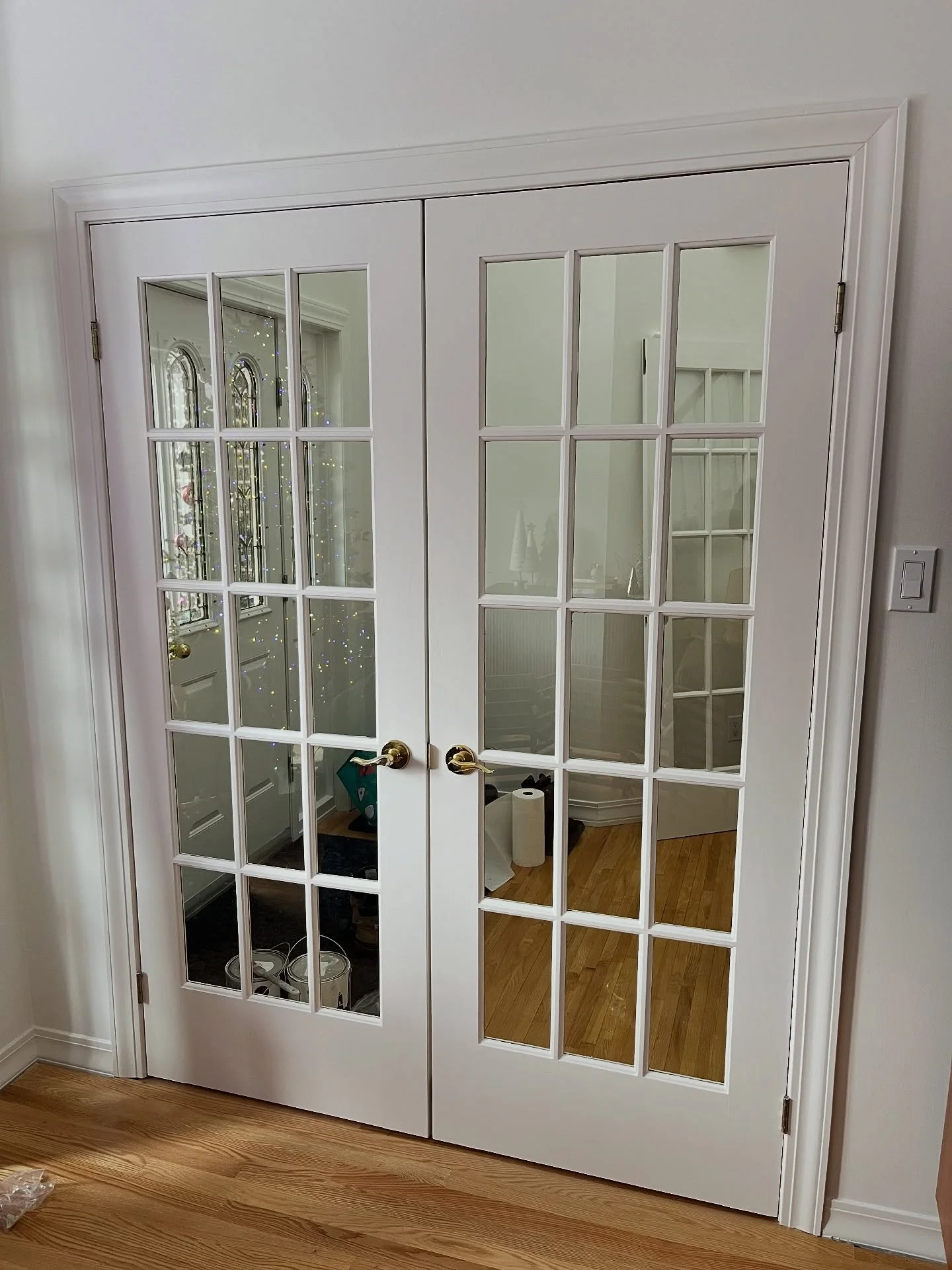 A bunch of French doors refinished and sprayed with Benjamin Moore white dove.