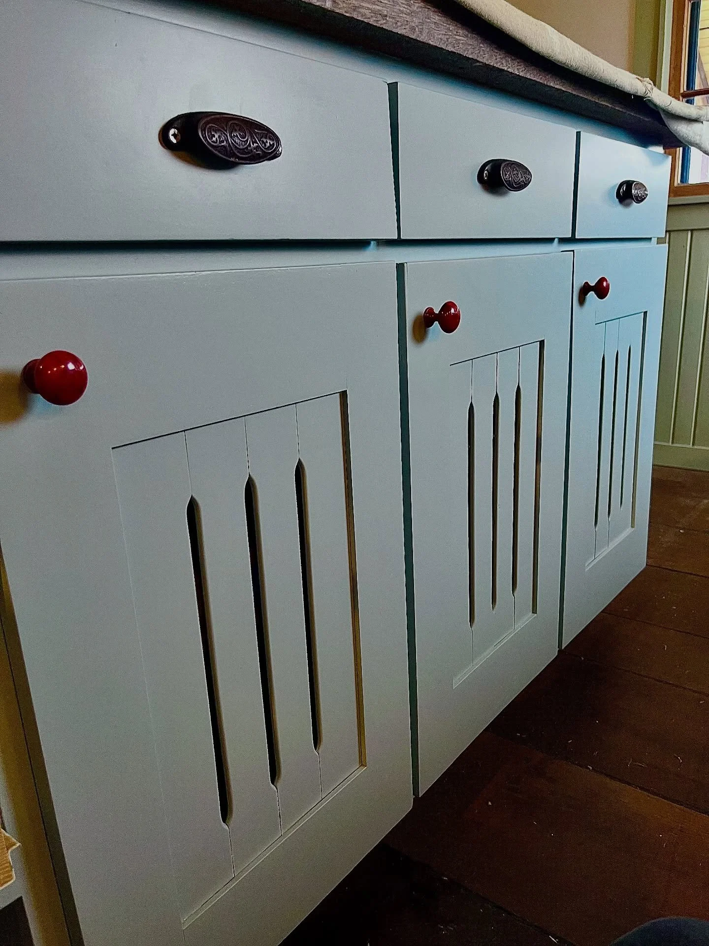 Reinstalling these newly sprayed Buxton Blue cabinet faces.