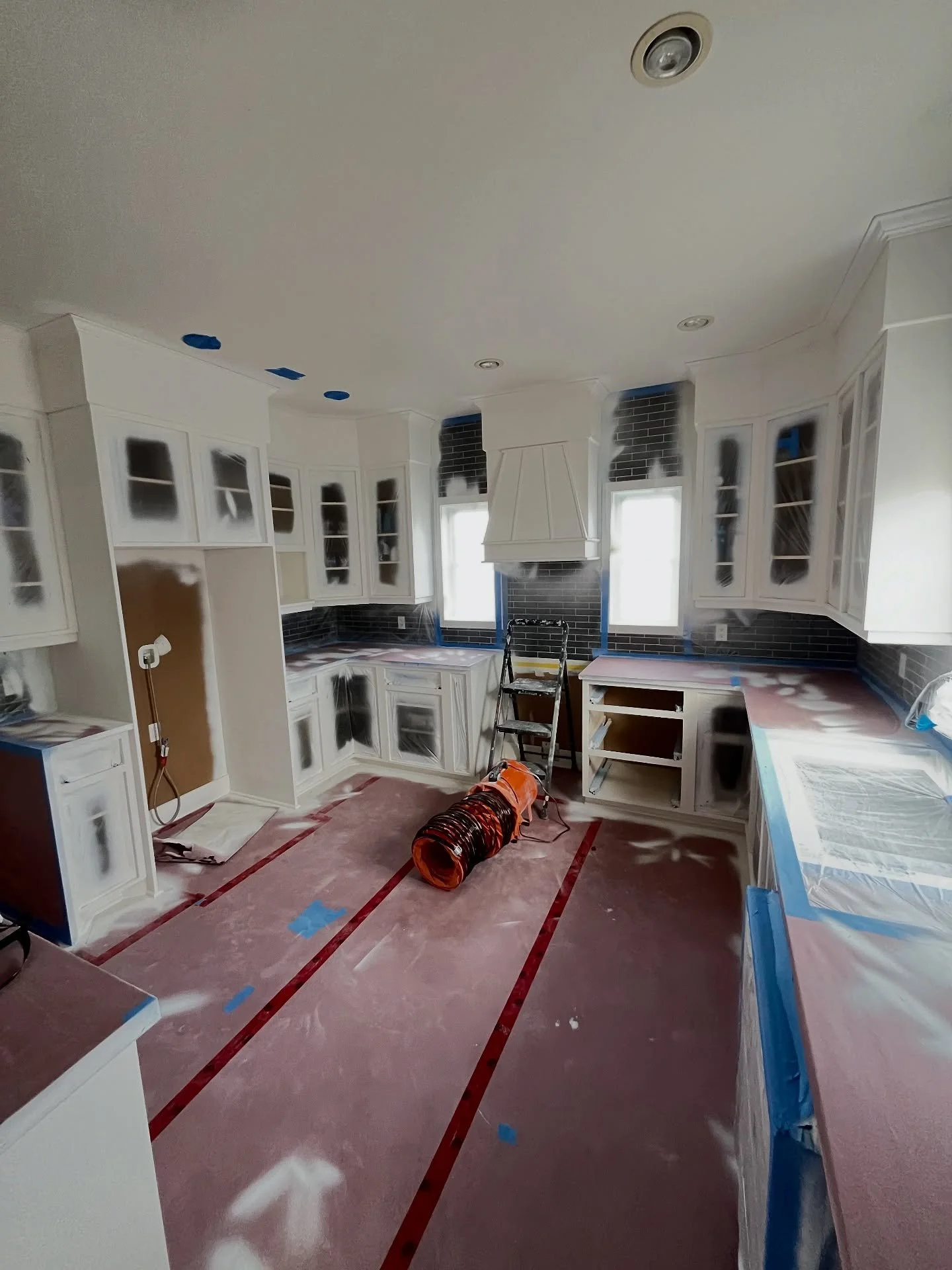 Spraying primer on kitchen boxes and staircase