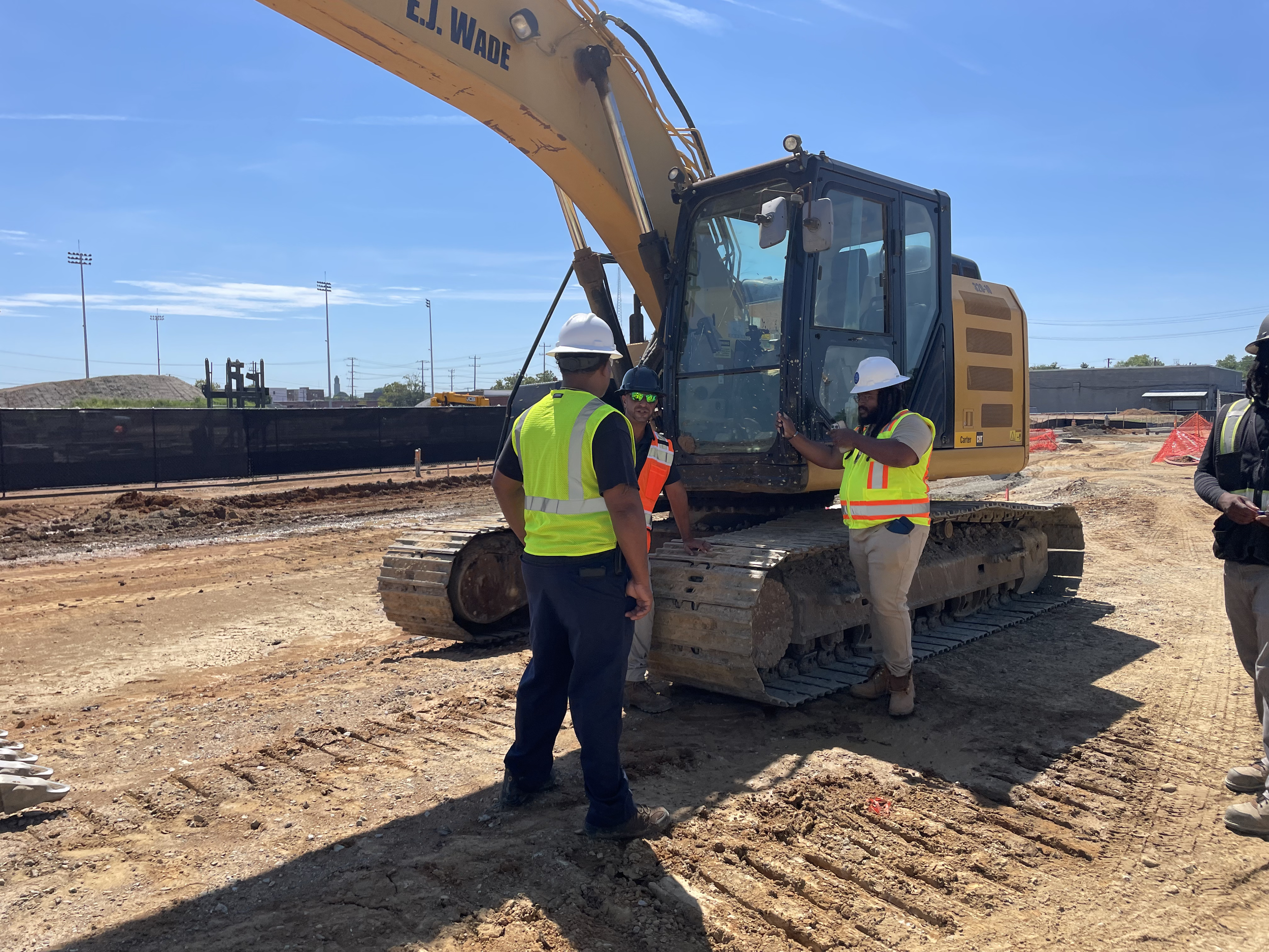 C&B field coordination next to excavator on active construction site