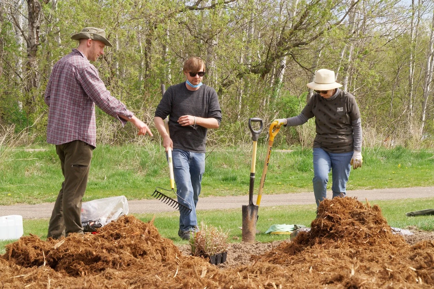 Landscape designer showing volunteers how and where to plant native plant plugs for a neighborhood pollinator and songbird garden in Stillwater, MN