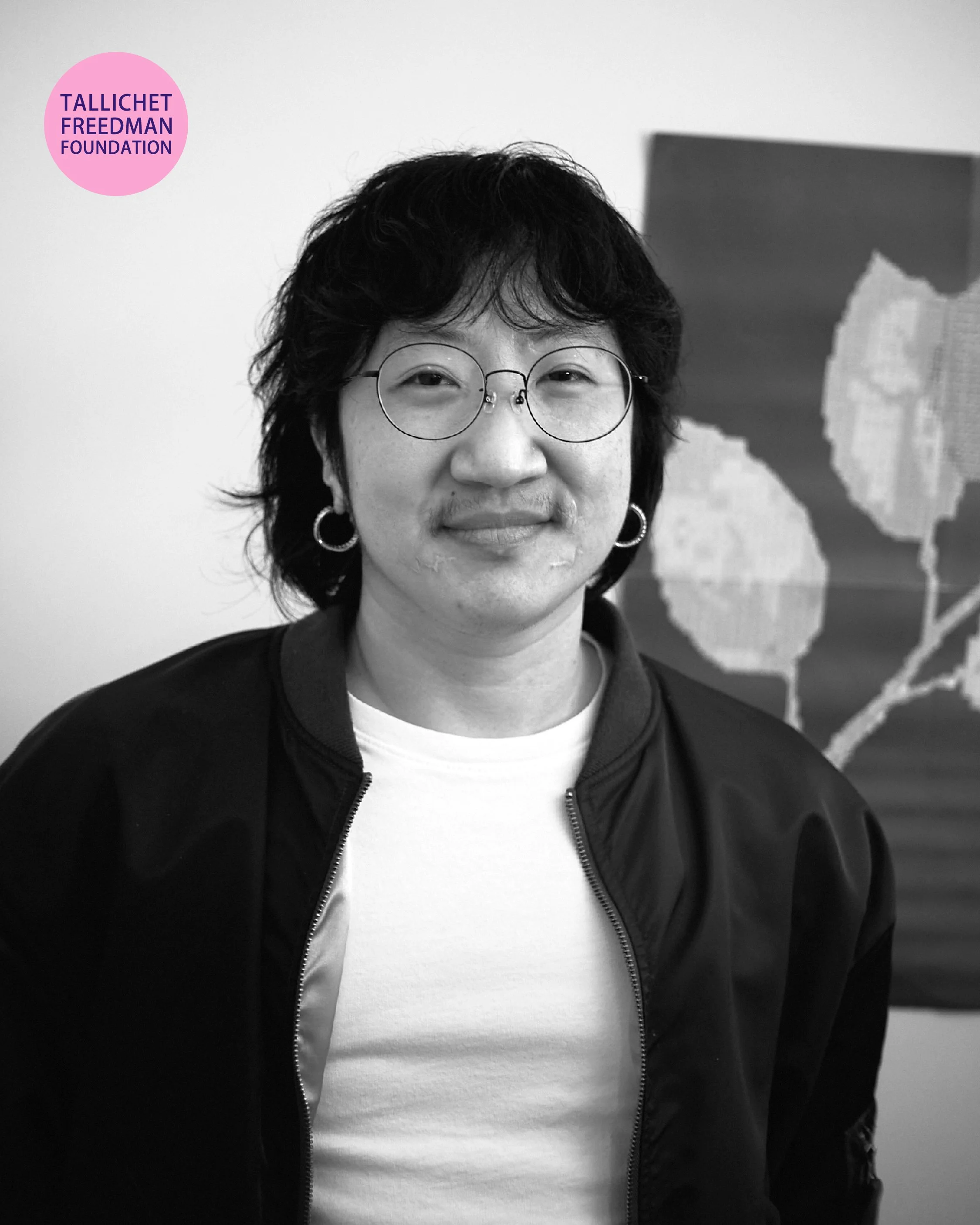 Queens artist Lu Yim in a close-up portrait during a filmed studio interview discussing their artistic practice.