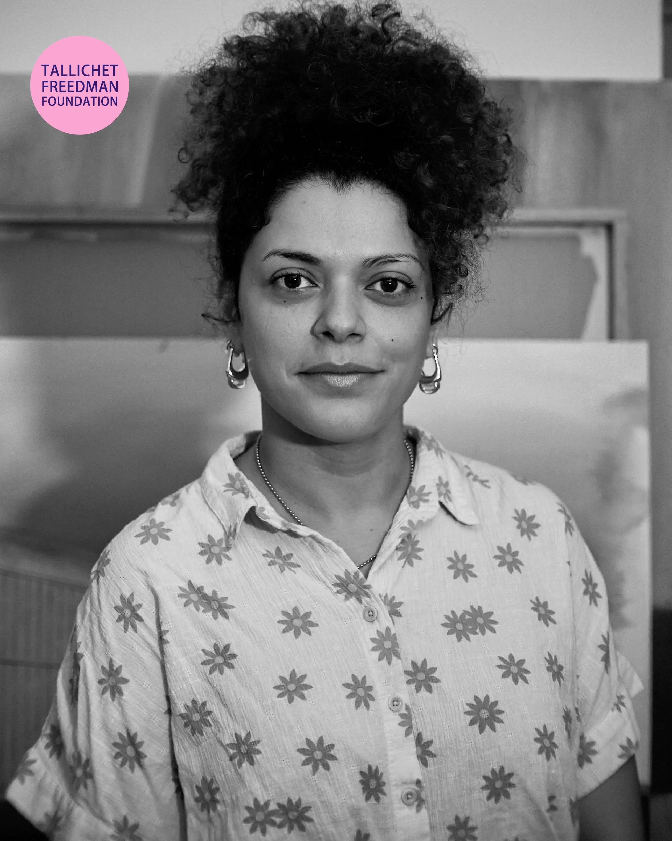 Queens artist Vyczie Dorado in a close-up portrait during a filmed studio interview discussing their artistic practice.