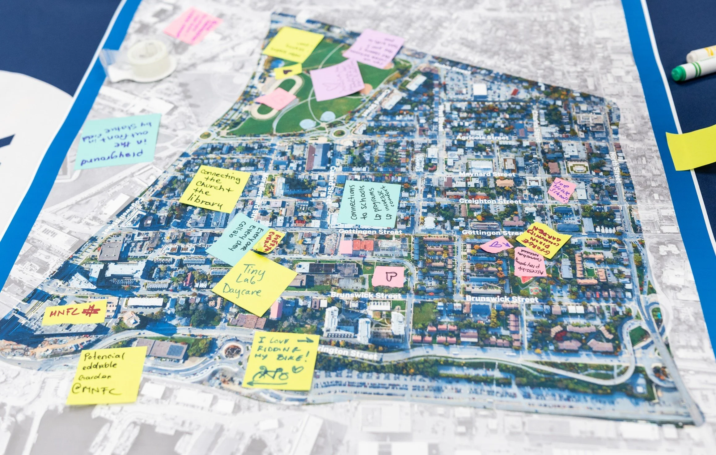  Map of North End neighbourhood with sticky notes placed on top. Some examples: “connecting the church and library”; “tiny lab daycare”; connections to schools”. 