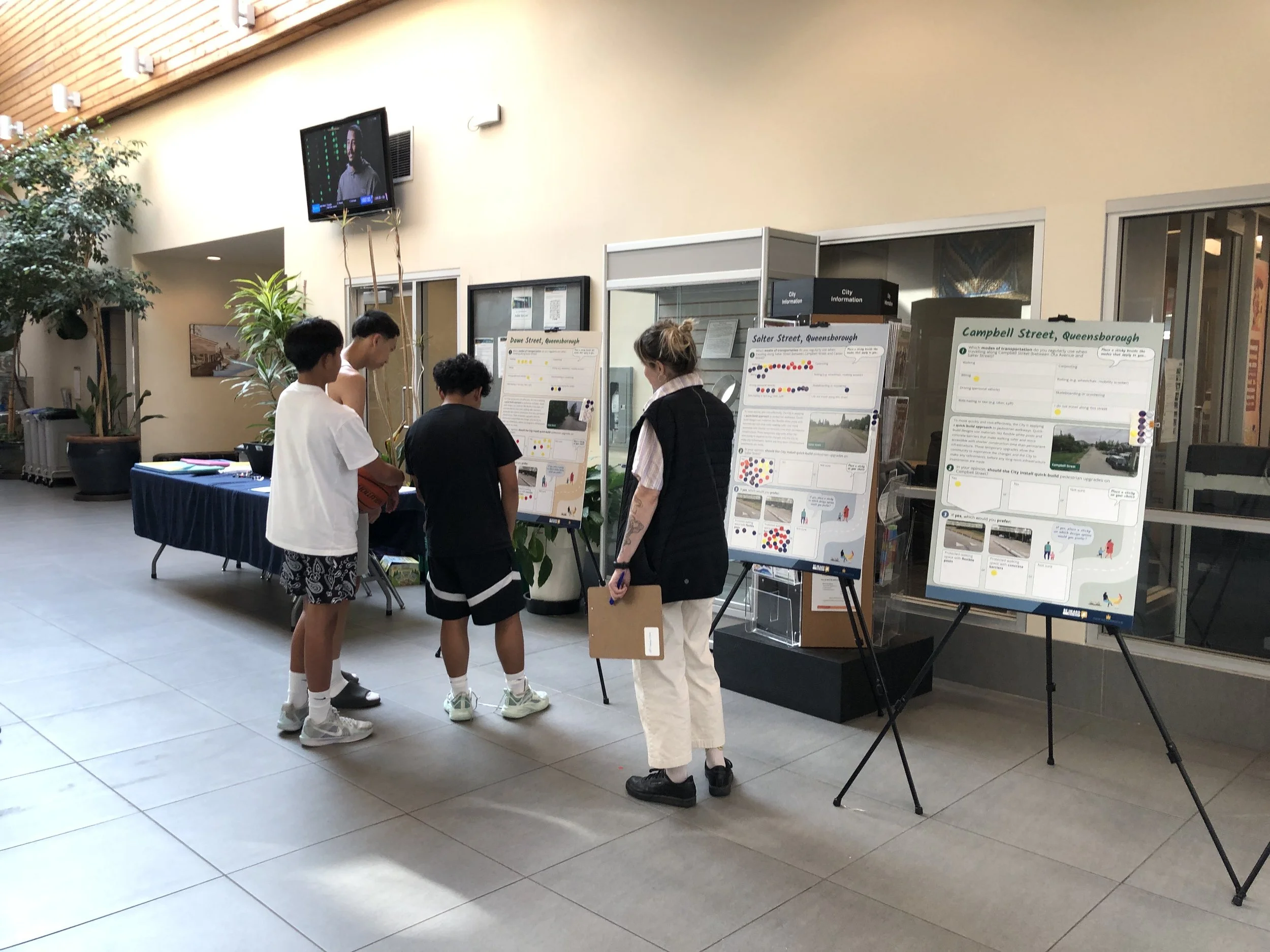 People with poster stands indoors.