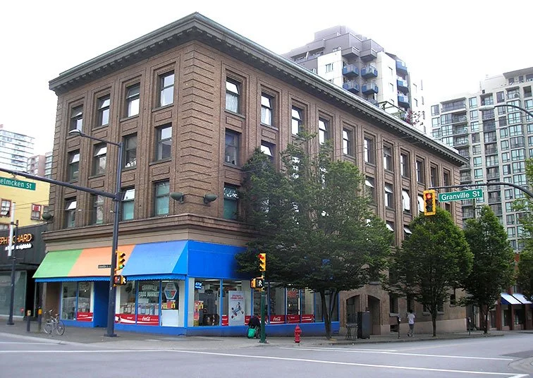 Helmcken House, a building with a food market on the ground floor and three floors of housing, on the corner of Helmcken and Granville St.
