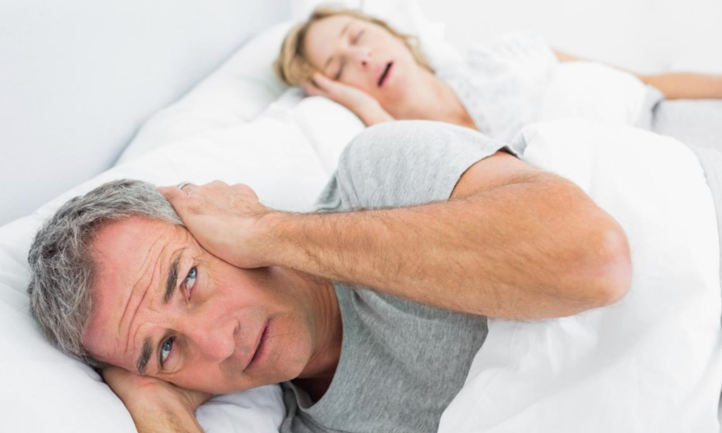 Partner covering their ears due to loud snoring, illustrating the impact of snoring on sleep and relationships, assessed and treated at Sleep Matters Clinic Wellington
