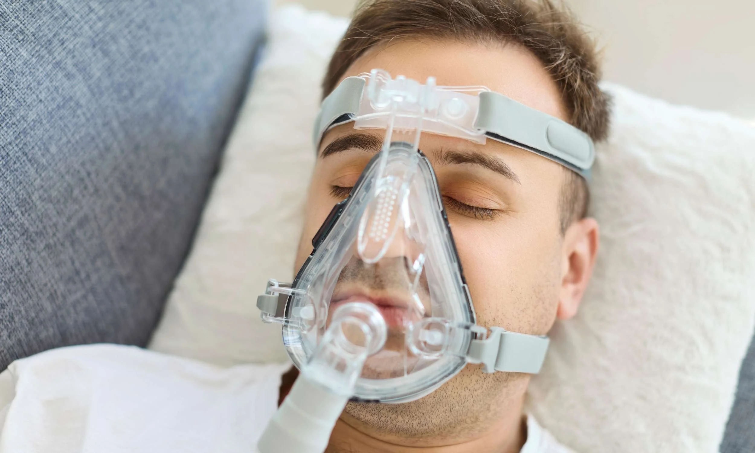 Person wearing a CPAP mask while sleeping, representing CPAP intolerance and alternative treatment options available at Sleep Matters Clinic Wellington