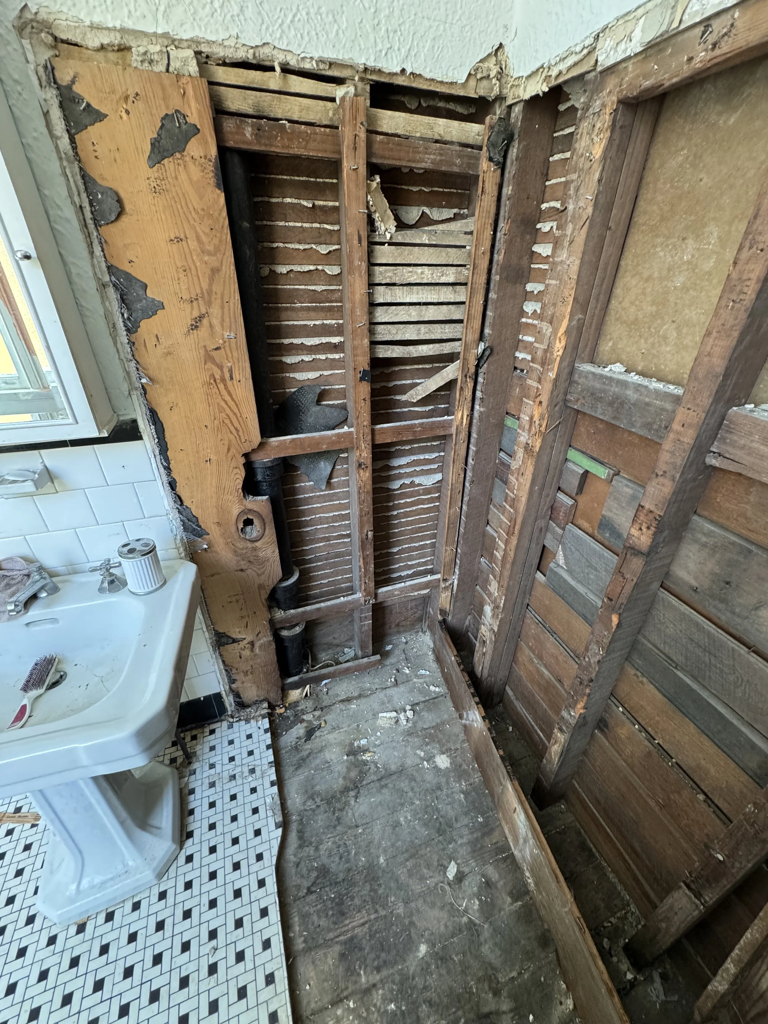 Bathroom demolition exposing wall framing for shower remodel and waterproofing preparation in New Orleans home