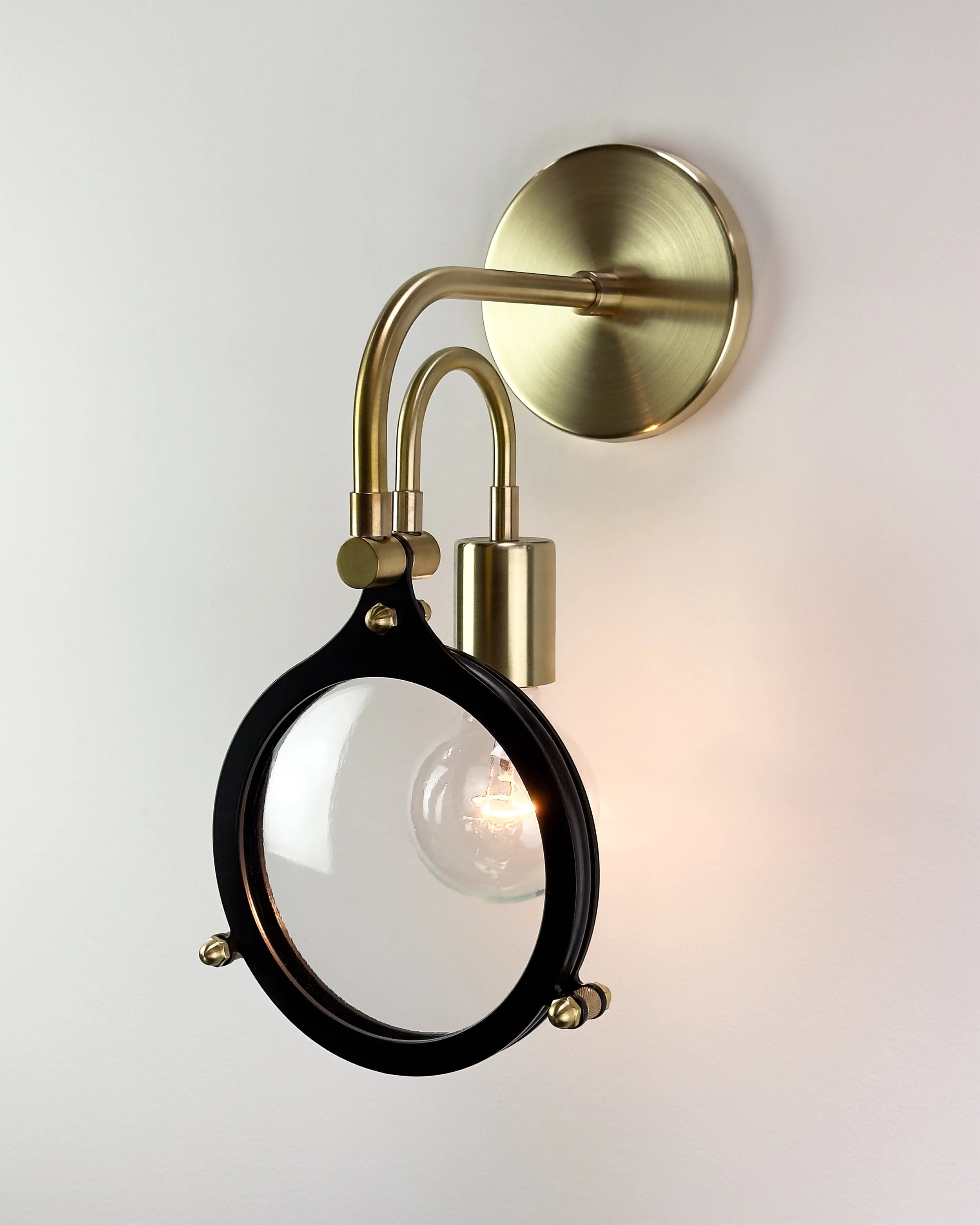 Lens Sconce by Neptune Glassworks—wall-mounted fixture with hand-shaped glass disc framed in a metal ring, inspired by tools of observation. Handcrafted in Los Angeles.