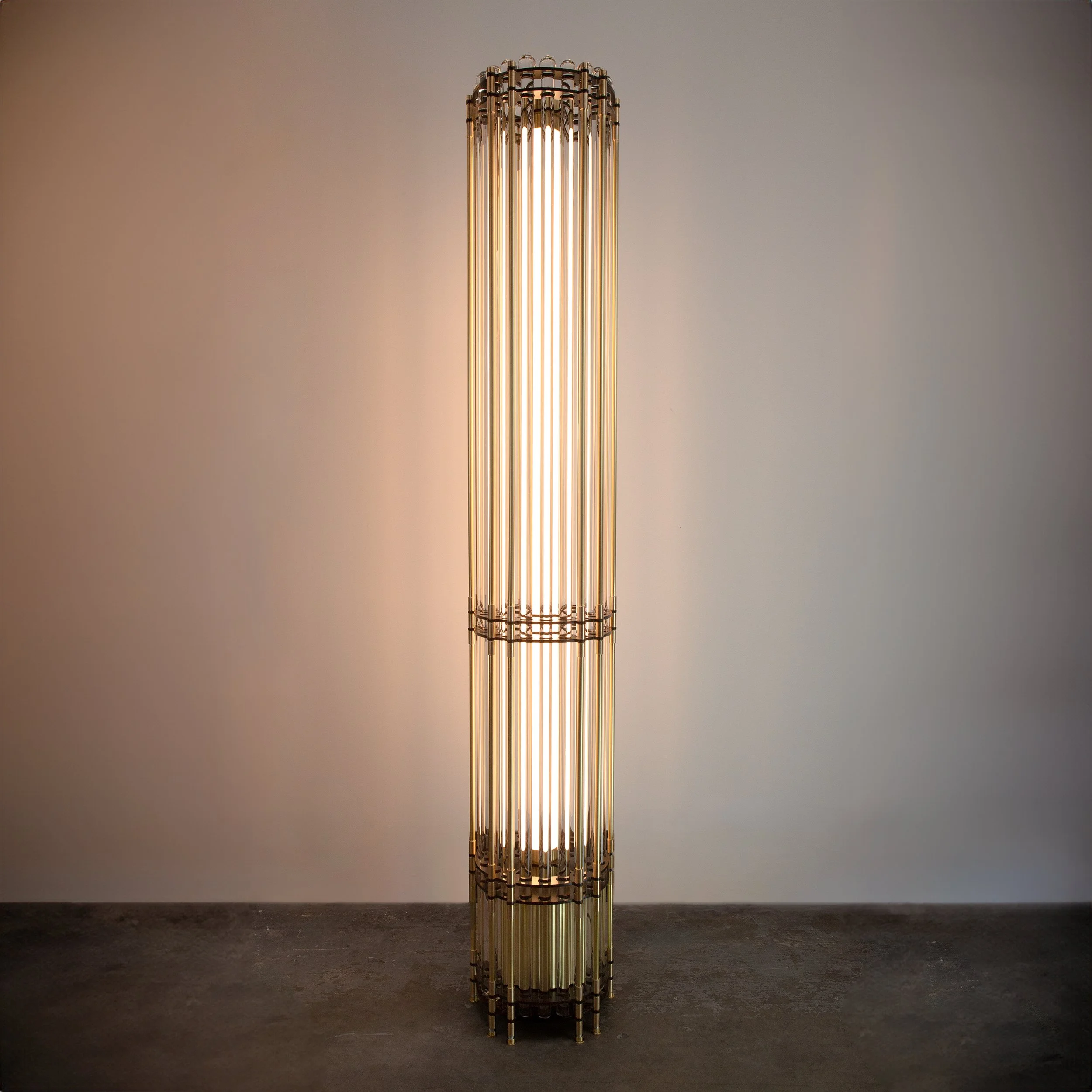 Tower Floor Lamp by Neptune Glassworks—floor-mounted fixture with stacked glass rods and machined brass plates, crowned with optical nodes that shimmer with light. Handcrafted in Los Angeles.