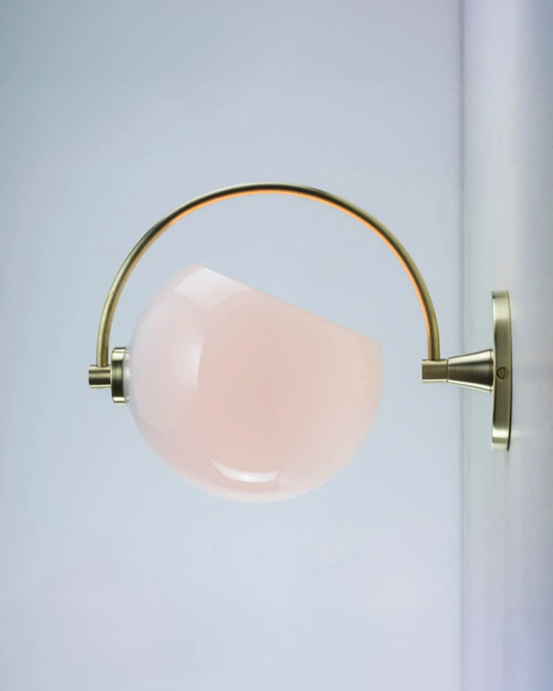 Phase Sconce by Neptune Glassworks—wall-mounted fixture with curved brass arm and glass hemisphere inspired by lunar phases. Handcrafted in Los Angeles.