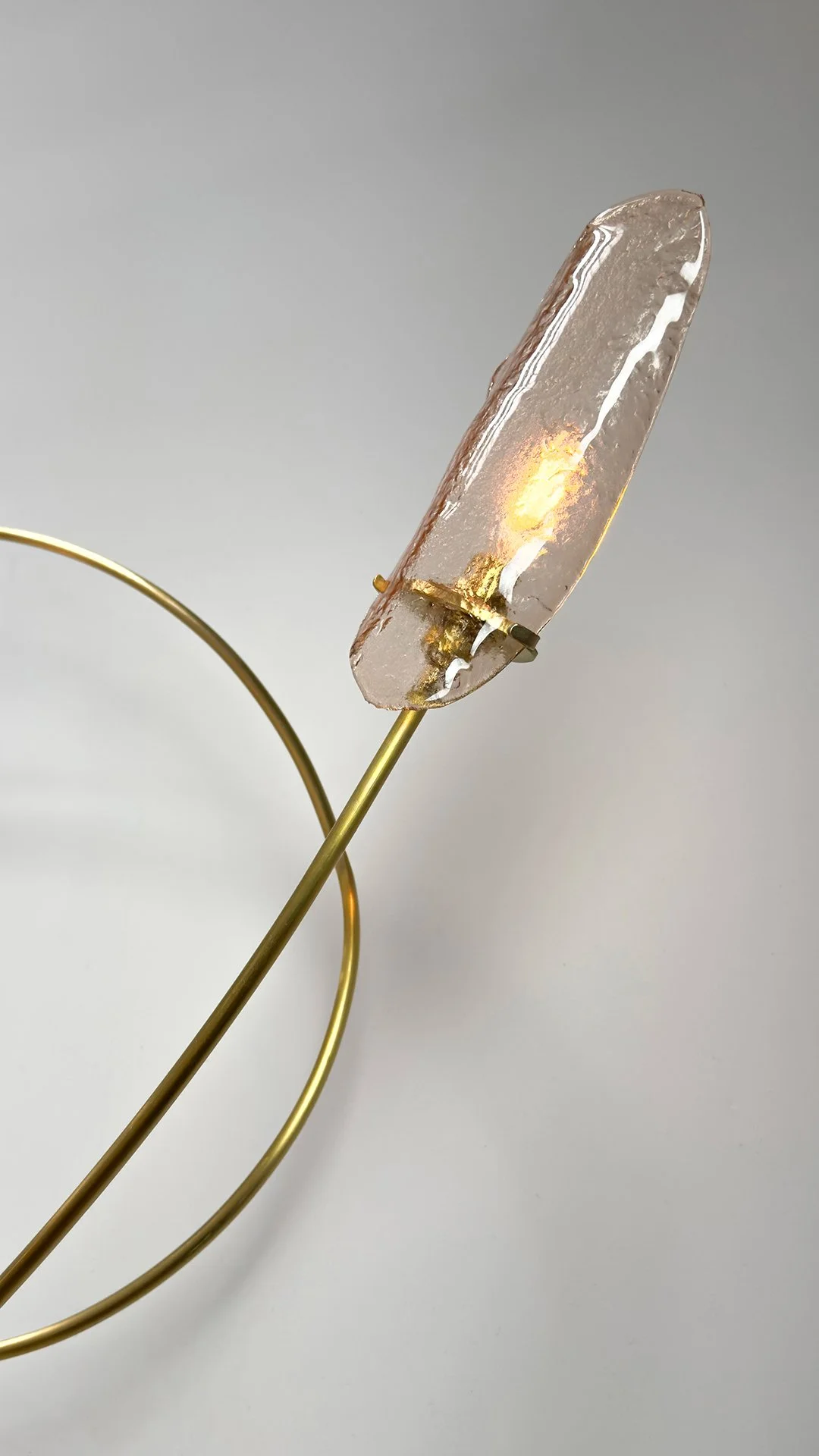 Scription Sconce by Neptune Glassworks—wall-mounted sculptural fixture with hand-bent brass arcs and illuminated tips, evoking signature-like gestures. Handcrafted in Los Angeles.