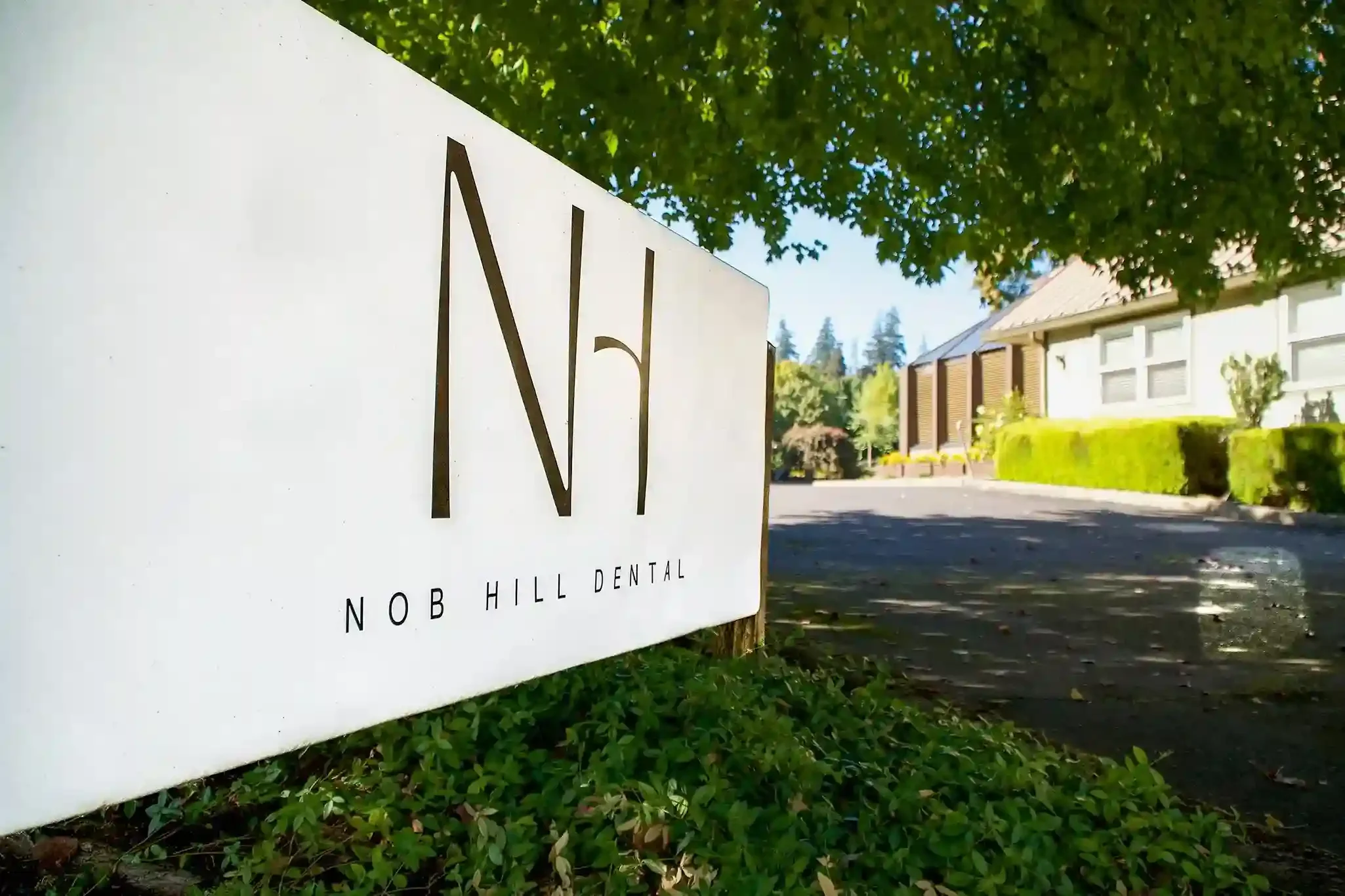 Nob Hill Dental office entrance sign surrounded by greenery