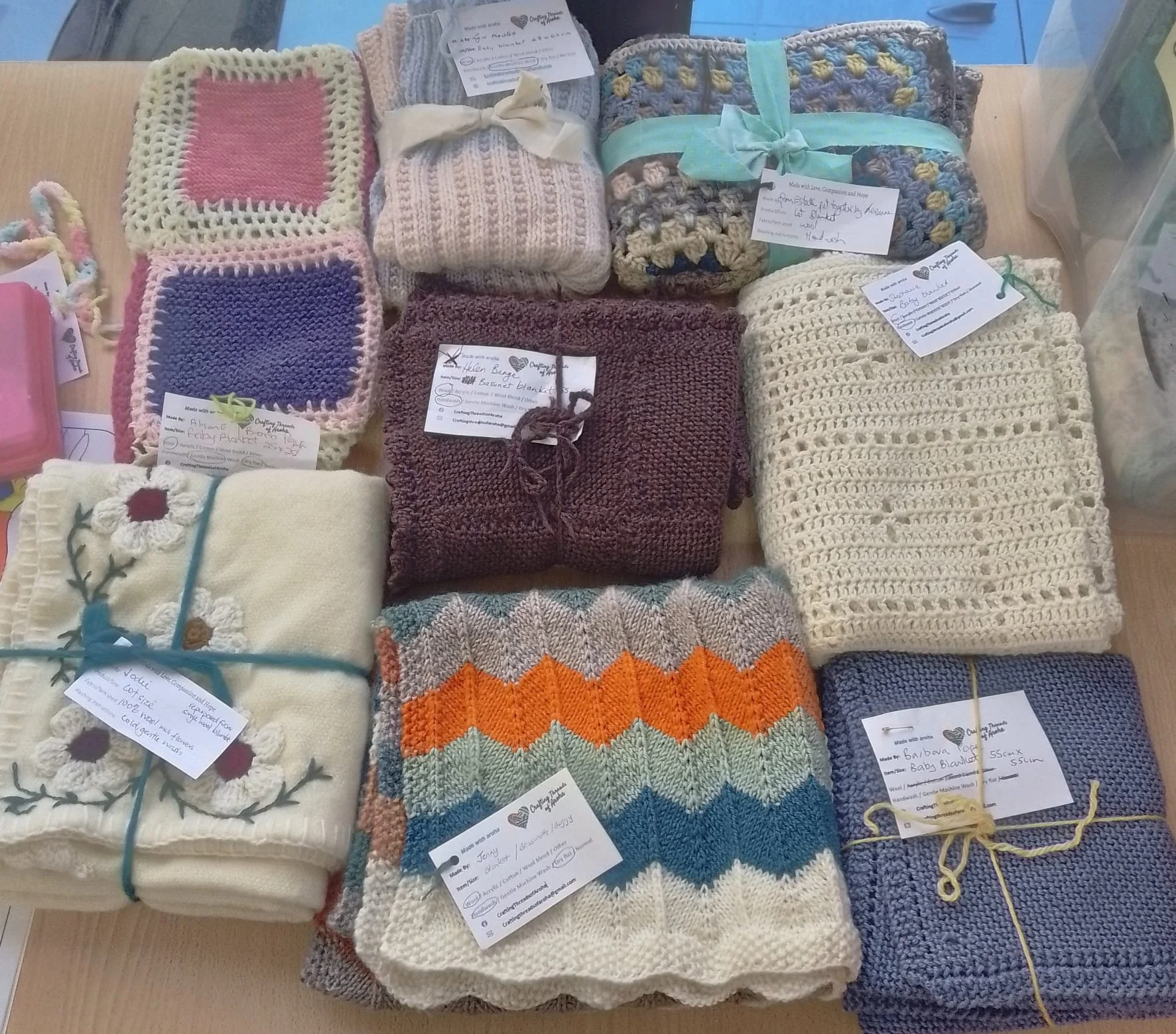 A table full of knitted and crocheted blankets
