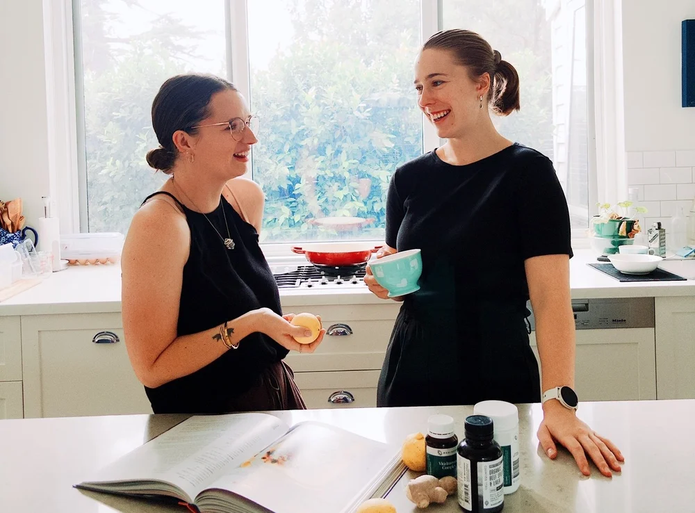 Jade and Georgia laughing together in a kitchen