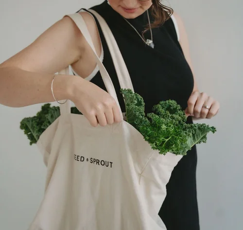 Jade with a tote bag full of kale