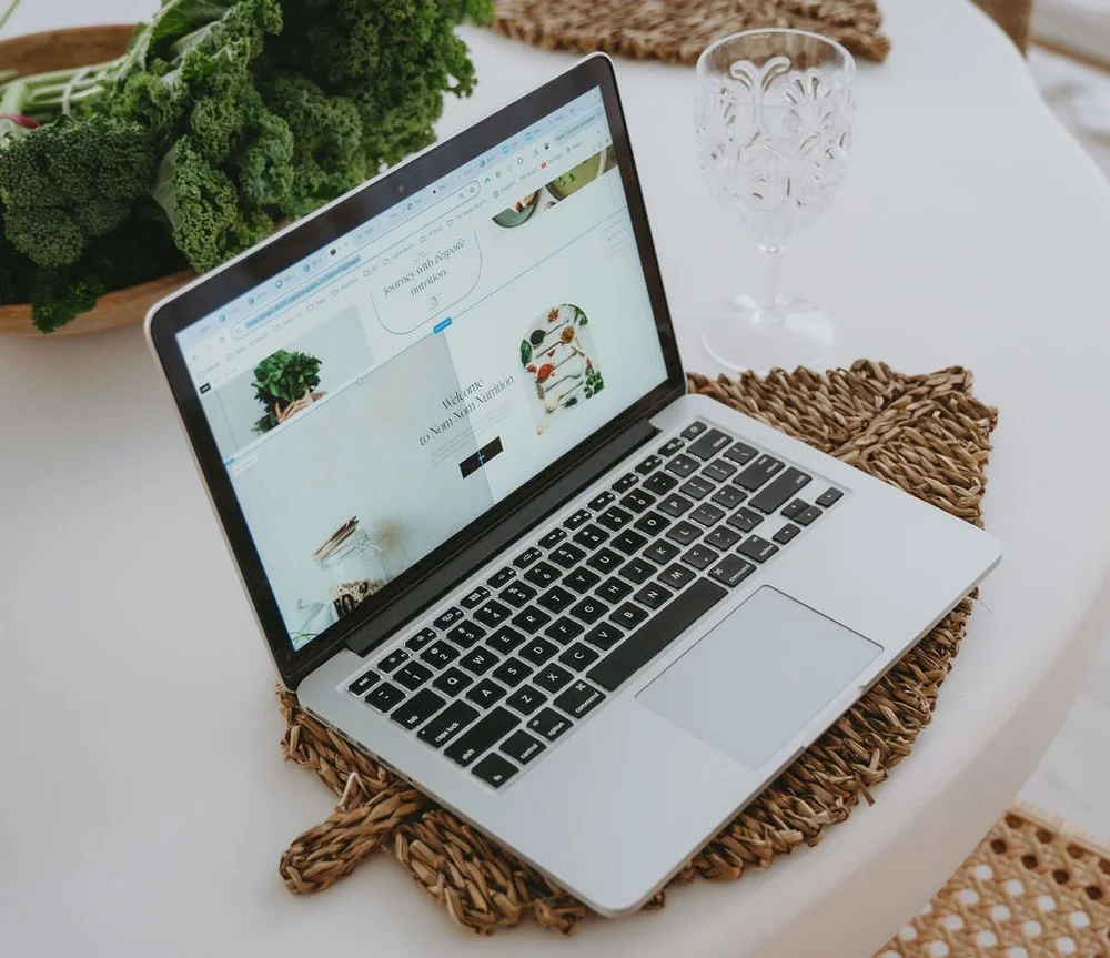 A laptop open to the Nom Nom Nutrition website