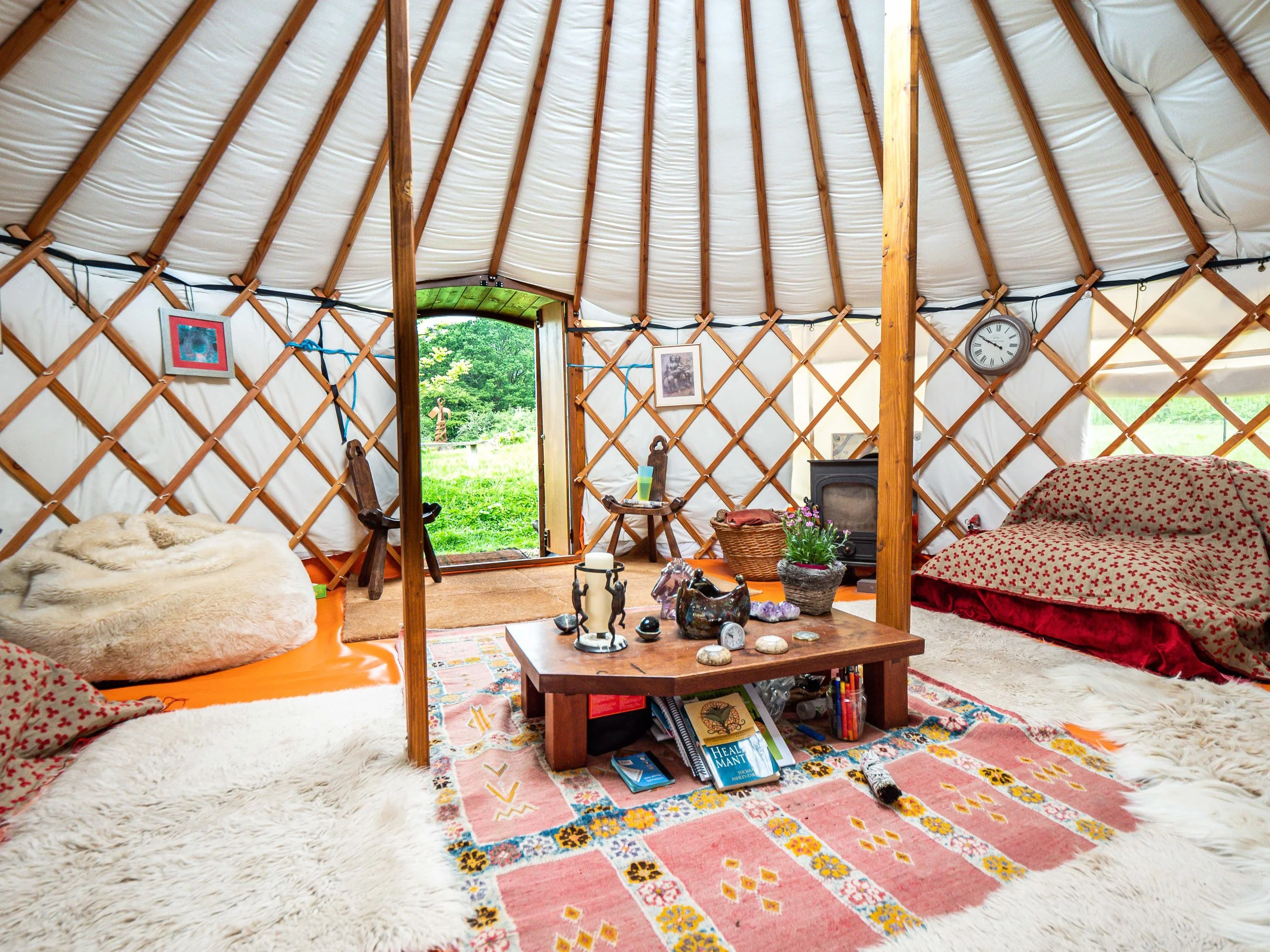 The yurt stands proudly amidst the lush green landscape, with the Black Mountains painting a stunning backdrop, illustrating the immersive nature experience offered at Llwyna Farm