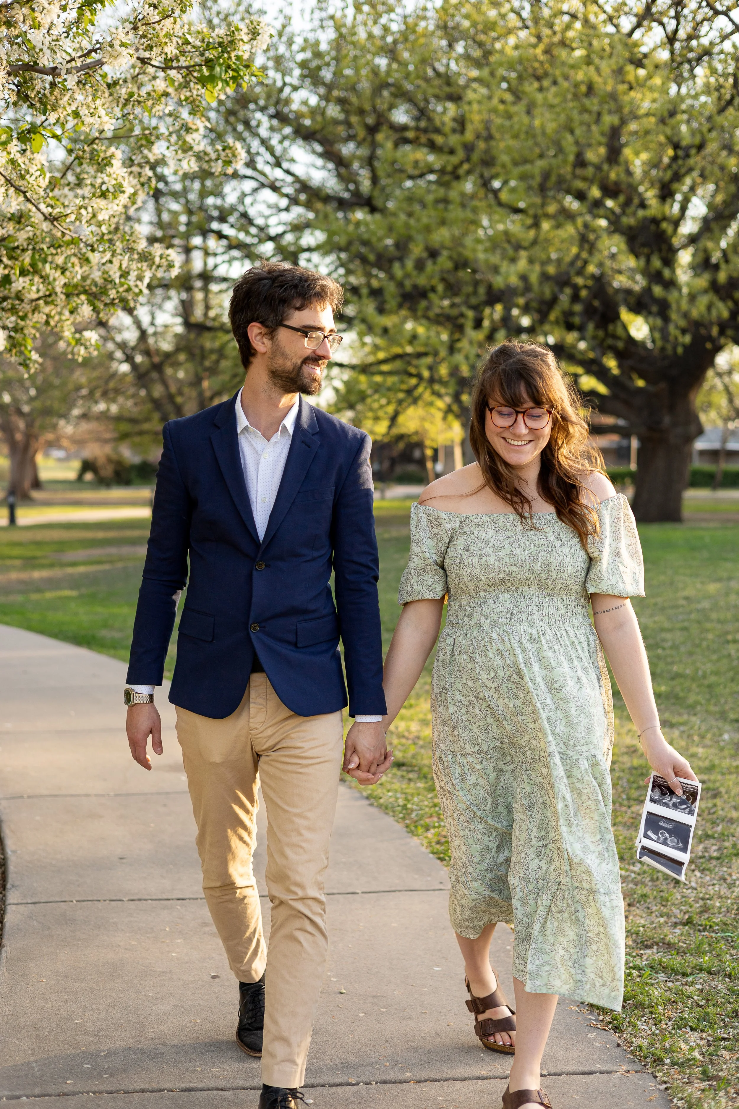 couple walking during spring maternity session in wichita ks