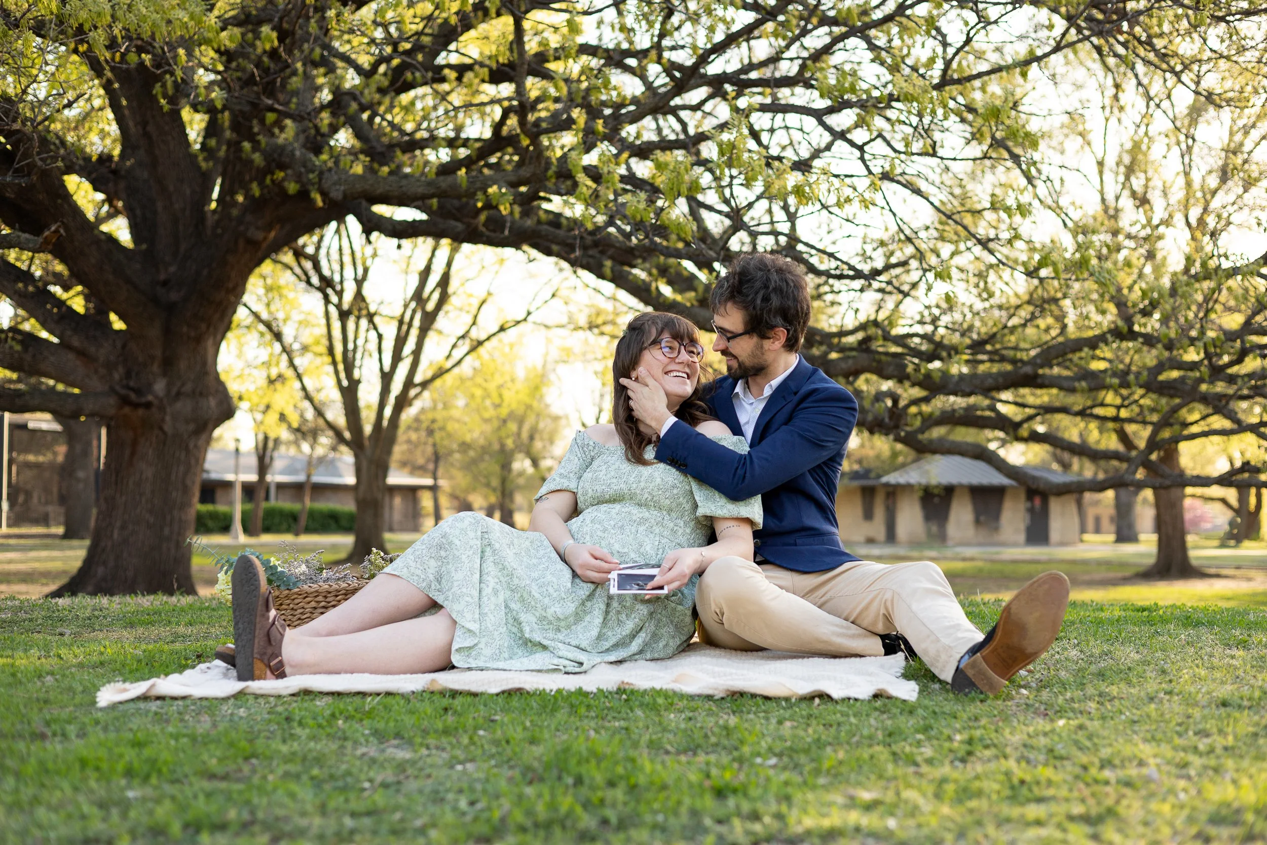 couple sitting on blanket together during spring maternity session in wichita ks