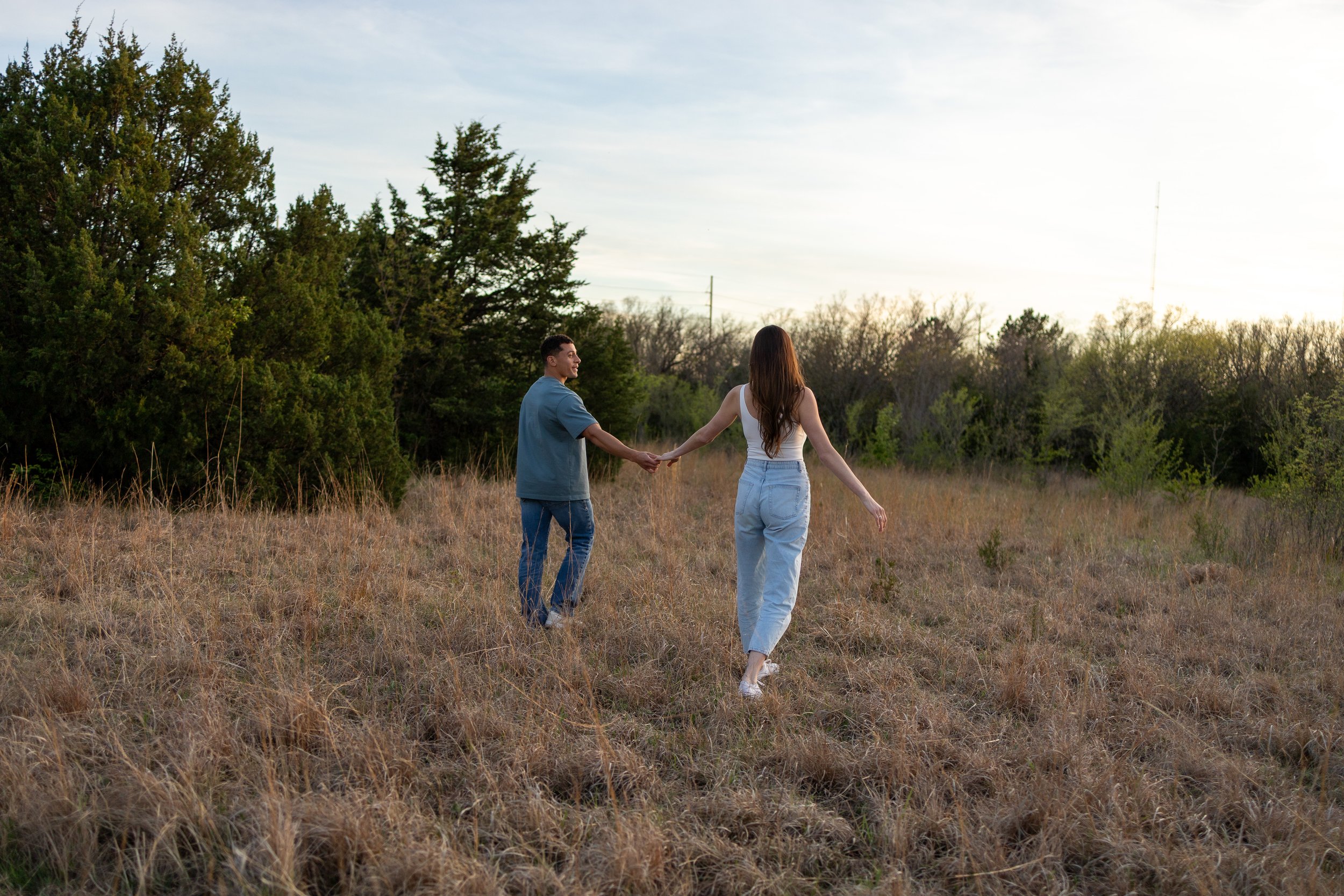 Couple walking through tall grass at Great Plains Nature Center during a Wichita couples session